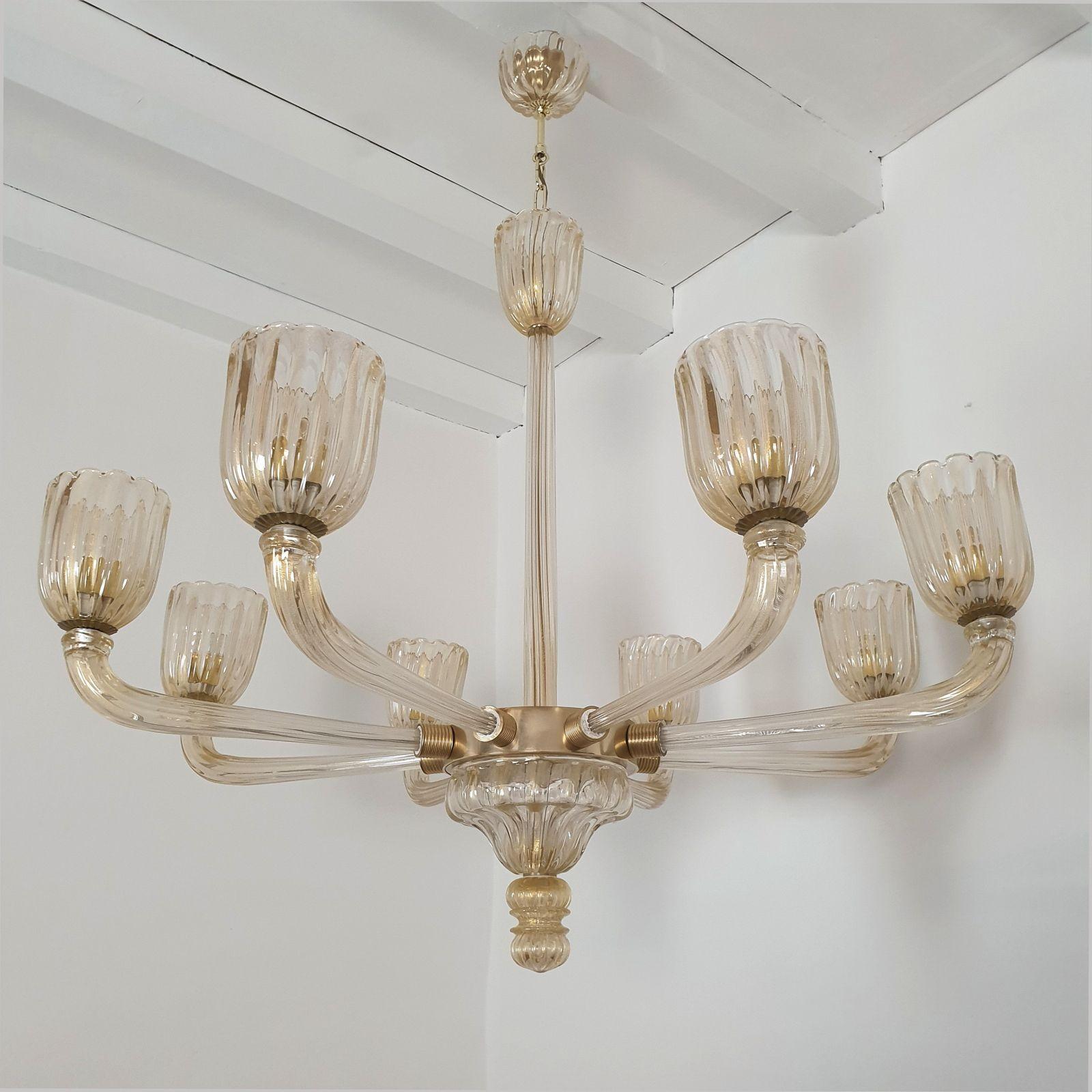 Large Mid Century Modern hand-blown Murano glass chandelier, attributed to Barovier, Italy 1970s.
The handmade Murano glass is thick, clear with real 24 carats gold flakes inclusion.
It make the glass translucent, and give a warm glow of light.
The