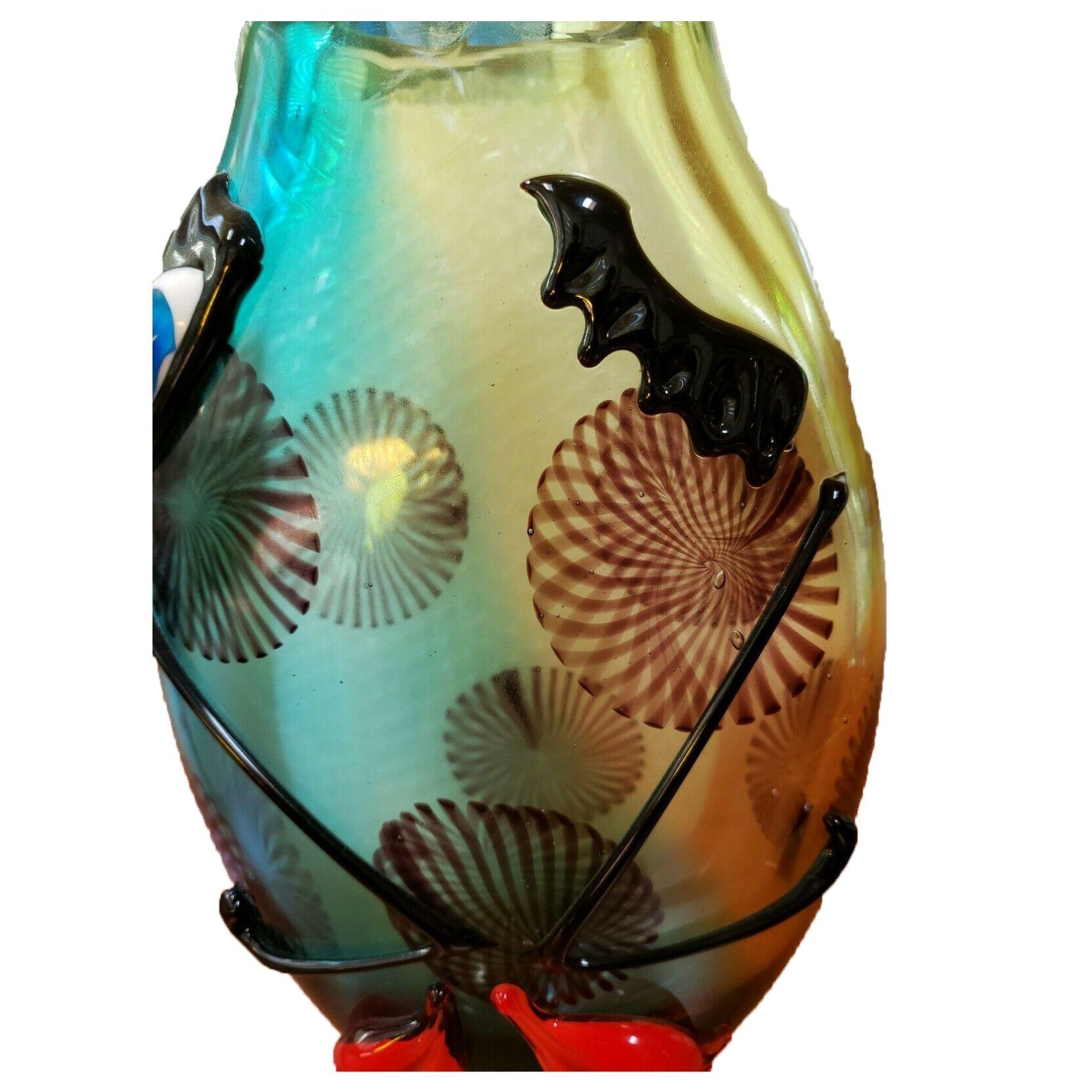 Per gli amanti di Murano, un affascinante vaso in vetro artistico in stile Picasso con faccia astratta e disegni di sfondo. Vetro soffiato a mano con colori diversi e caratteristiche facciali esterne in muratura; dimensioni: 12,5 pollici di altezza