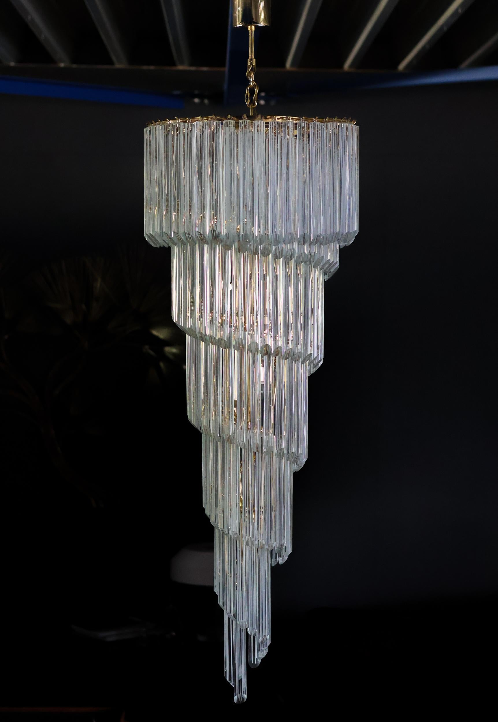 Eleva il tuo spazio con l'eleganza senza tempo di questo grande lampadario a spirale di Murano, realizzato dai maestri vetrai di Murano, in Italia, con la secolare tecnica della Filigrana. Caratterizzato da una cascata mozzafiato di elementi in