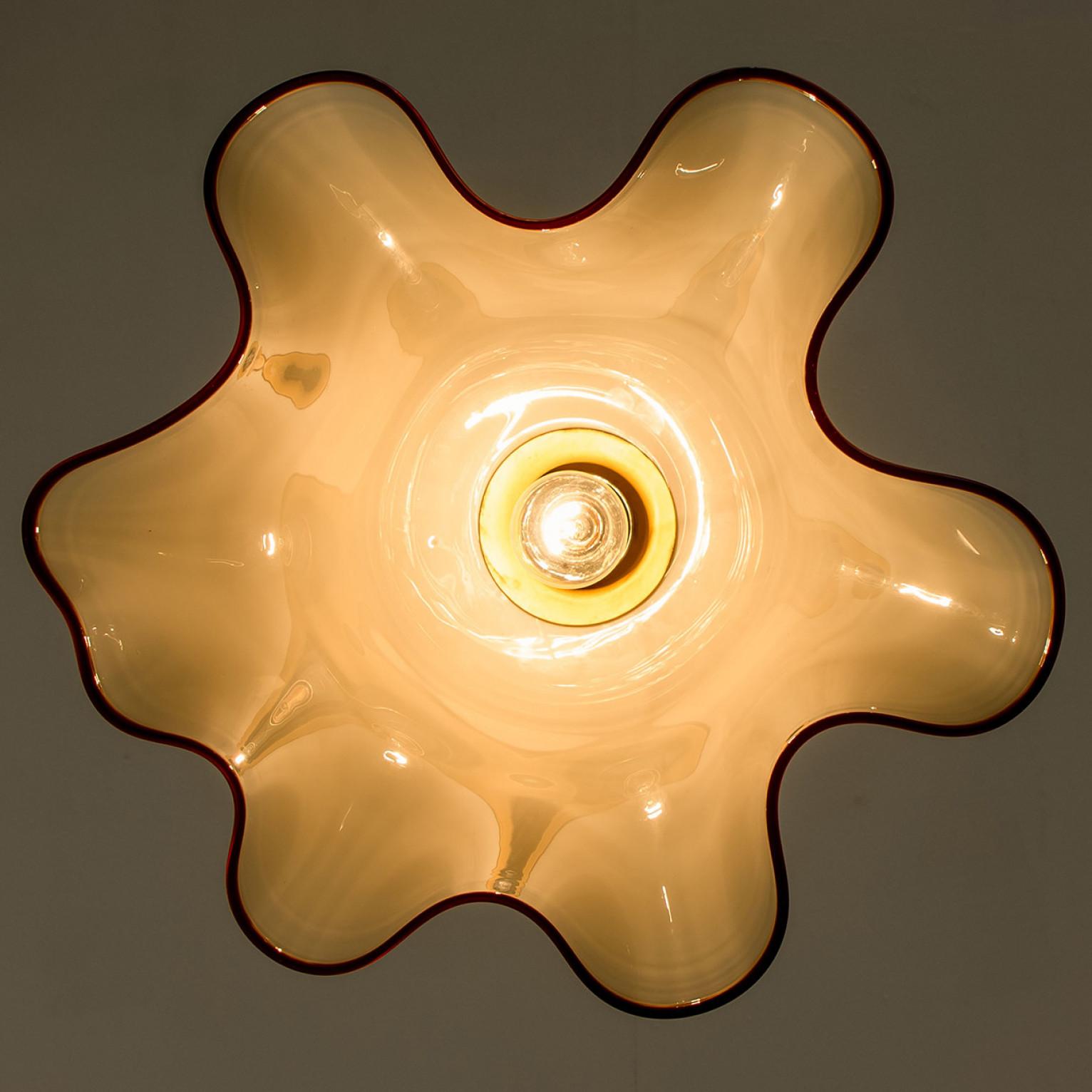 Mid century brass chandelier in the shape of a flower by J.T. Kalmar, Austria around 1970.
Illuminates beautifully.

Designed and executed by Kalmar Vienna in the 1970s. The white/yellow opaque glass shows a red border. The lamps is in the style of