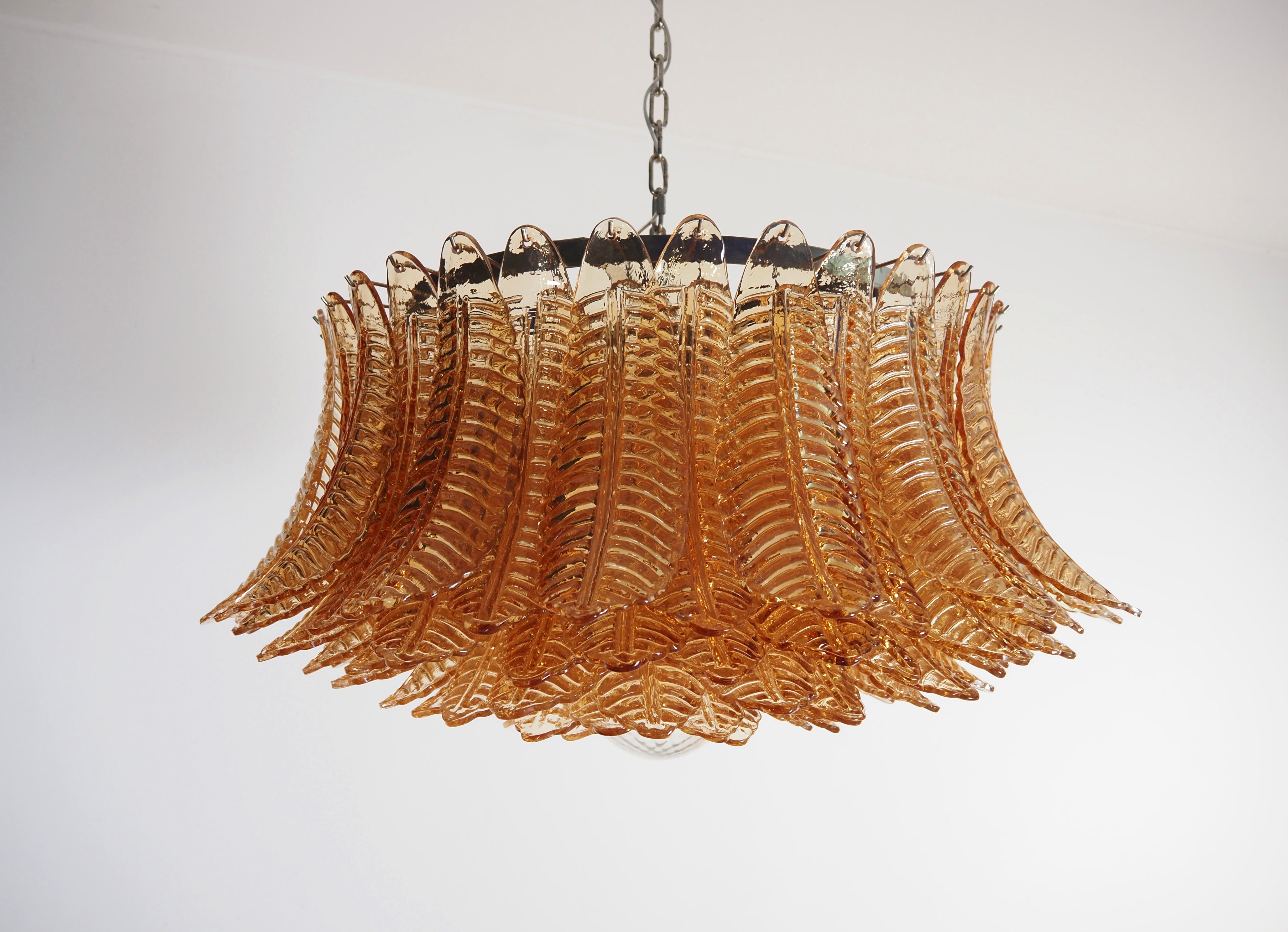 Araña italiana vintage de cristal de Murano y estructura de metal niquelado. La armadura de níquel pulido soporta 100 grandes hojas de cristal ámbar felci más una esfera de cristal utilizada como remate rosa. Se puede utilizar como lámpara de araña