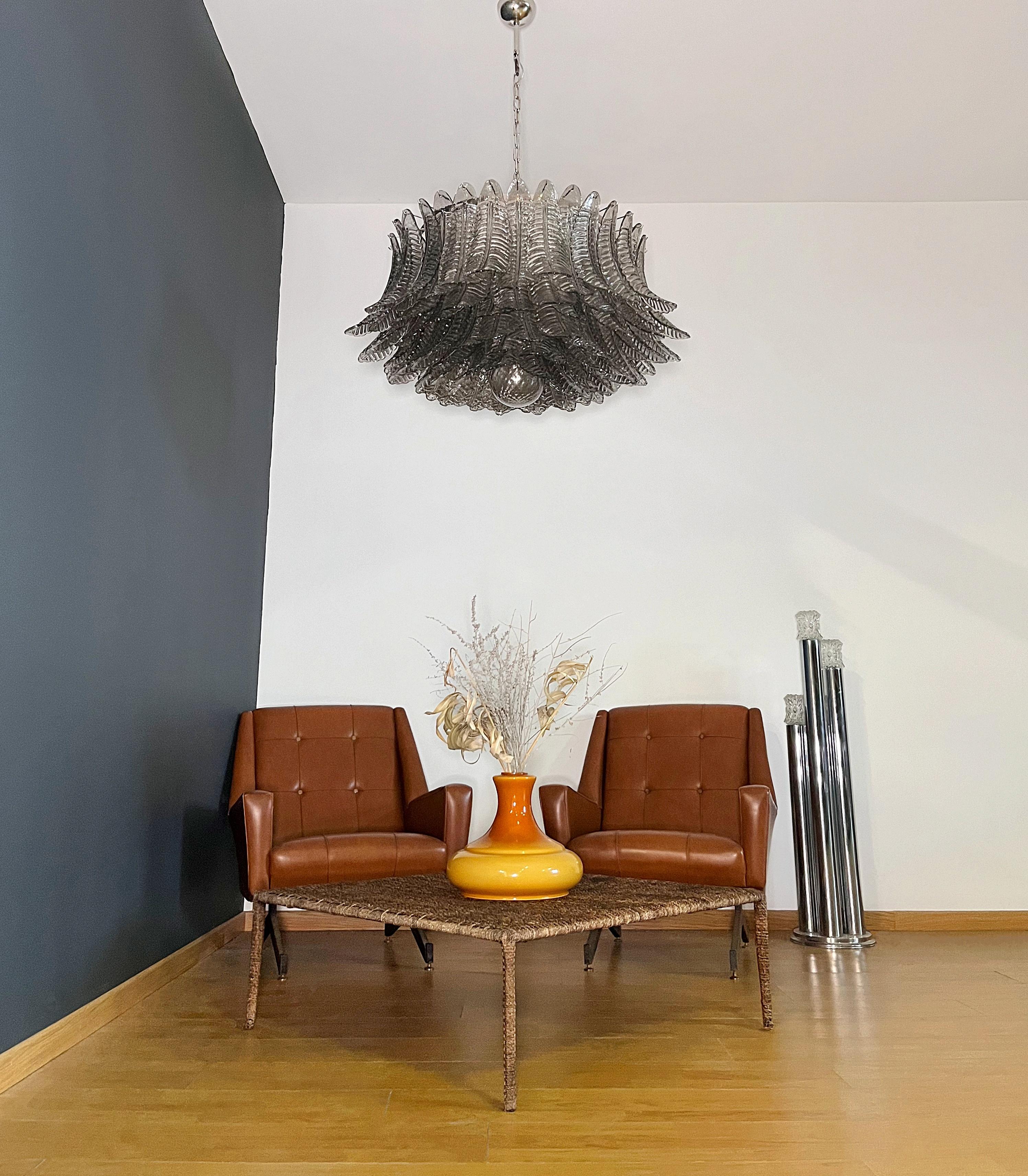 Araña vintage italiana de cristal de Murano y estructura de metal niquelado. La armadura de níquel pulido soporta 100 grandes hojas de helecho de cristal ahumado, además de una esfera de cristal utilizada como acabado rosa. Puede utilizarse como