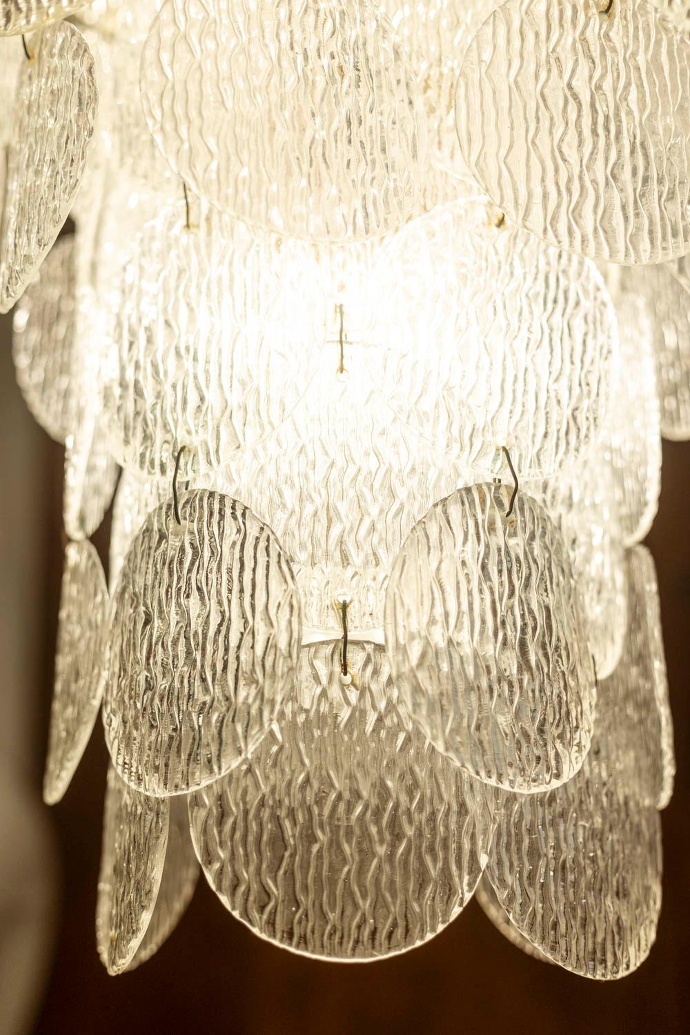 Grande lampadario in vetro di Murano, in stile Art Déco, composto da cerchi appoggiati su una struttura in metallo.

Opera italiana realizzata negli anni '1970.