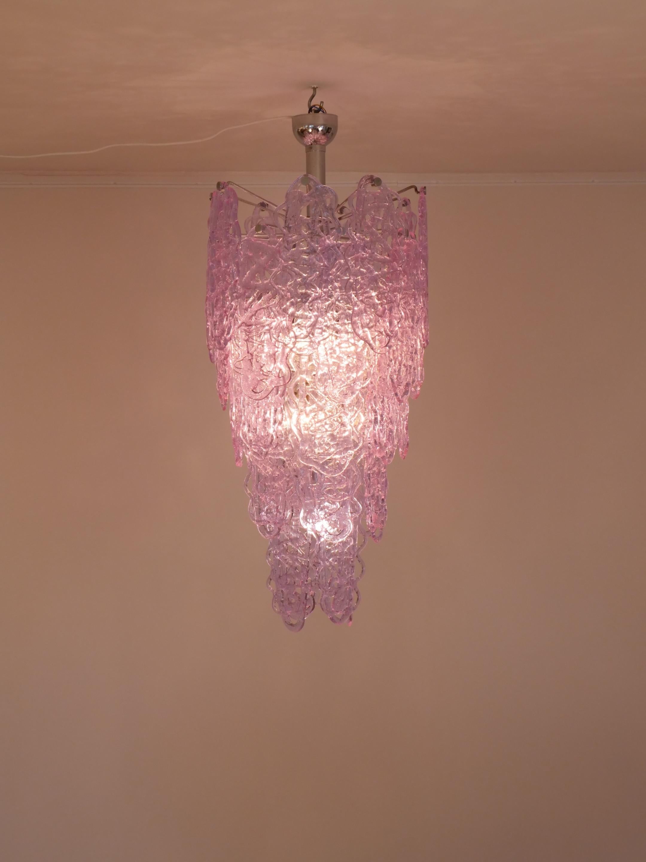 Magnifique lustre original en verre de Murano par Mazzega. La couleur est un violet / mauve semi-opaque.

Les morceaux de verre ressemblent à des bonbons de sucre filé

