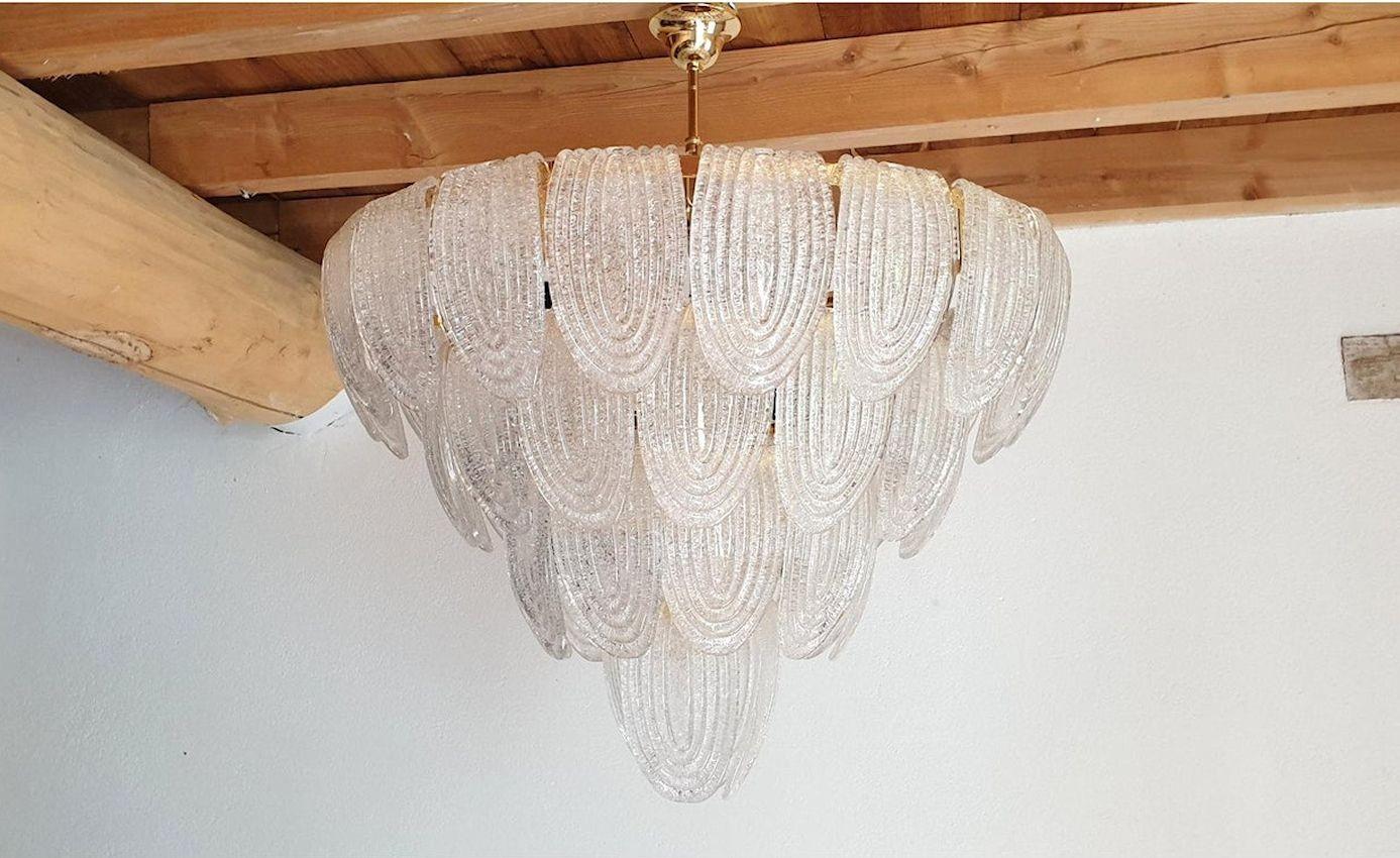 Moderner Murano-Glaslüster aus der Jahrhundertmitte, Mazzega, Italien, 1980er Jahre.
Großer Kronleuchter aus durchscheinendem und strukturiertem Murano-Glas im Vintage-Stil, mit vergoldetem Rahmen, Baldachin und Kette.
Ein Paar verfügbar: Preis und
