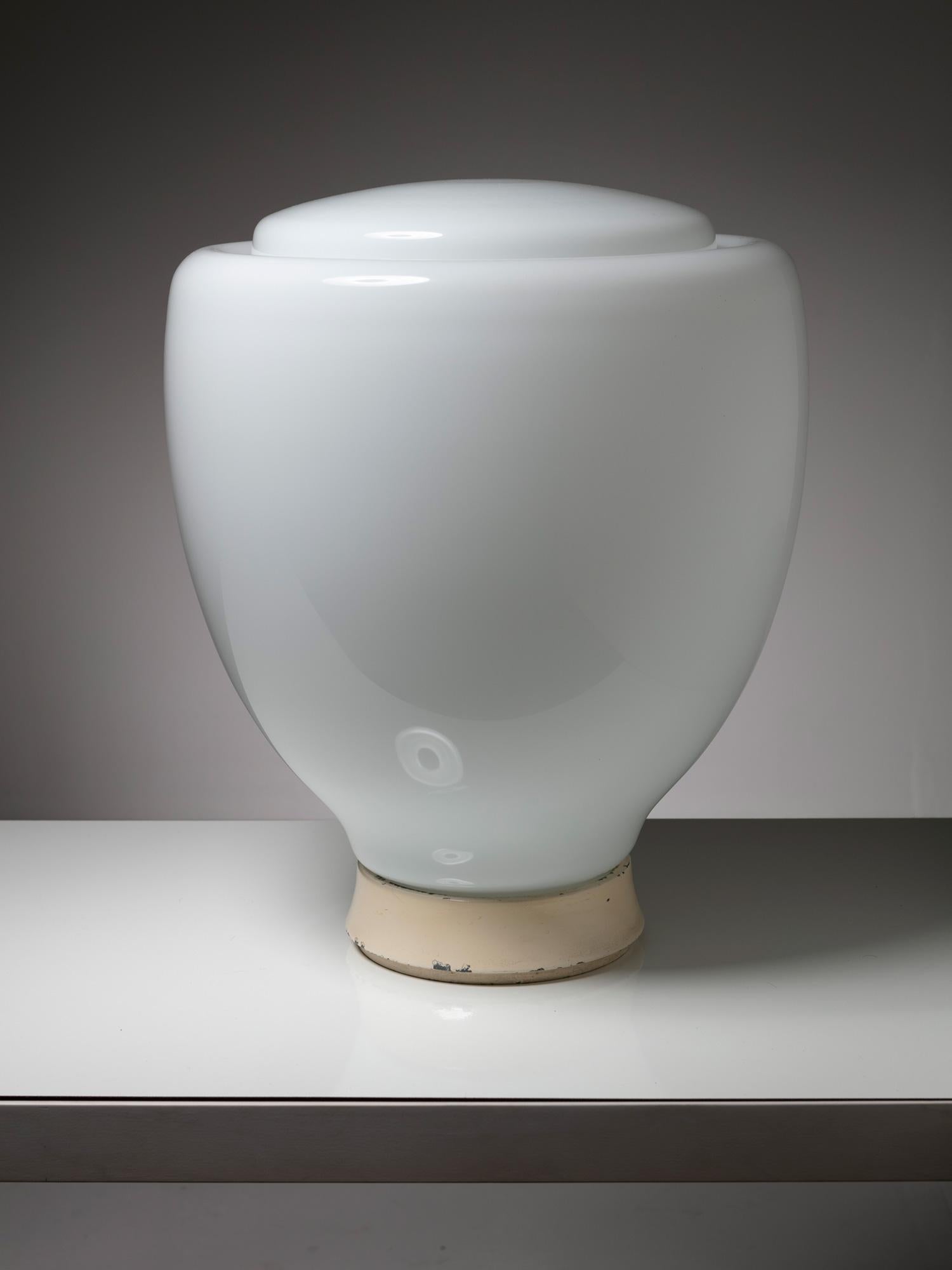 Lampada da tavolo Ellisse di Claudio Salocchi per Lumenform.
Grande paralume in vetro opalino e base in metallo.