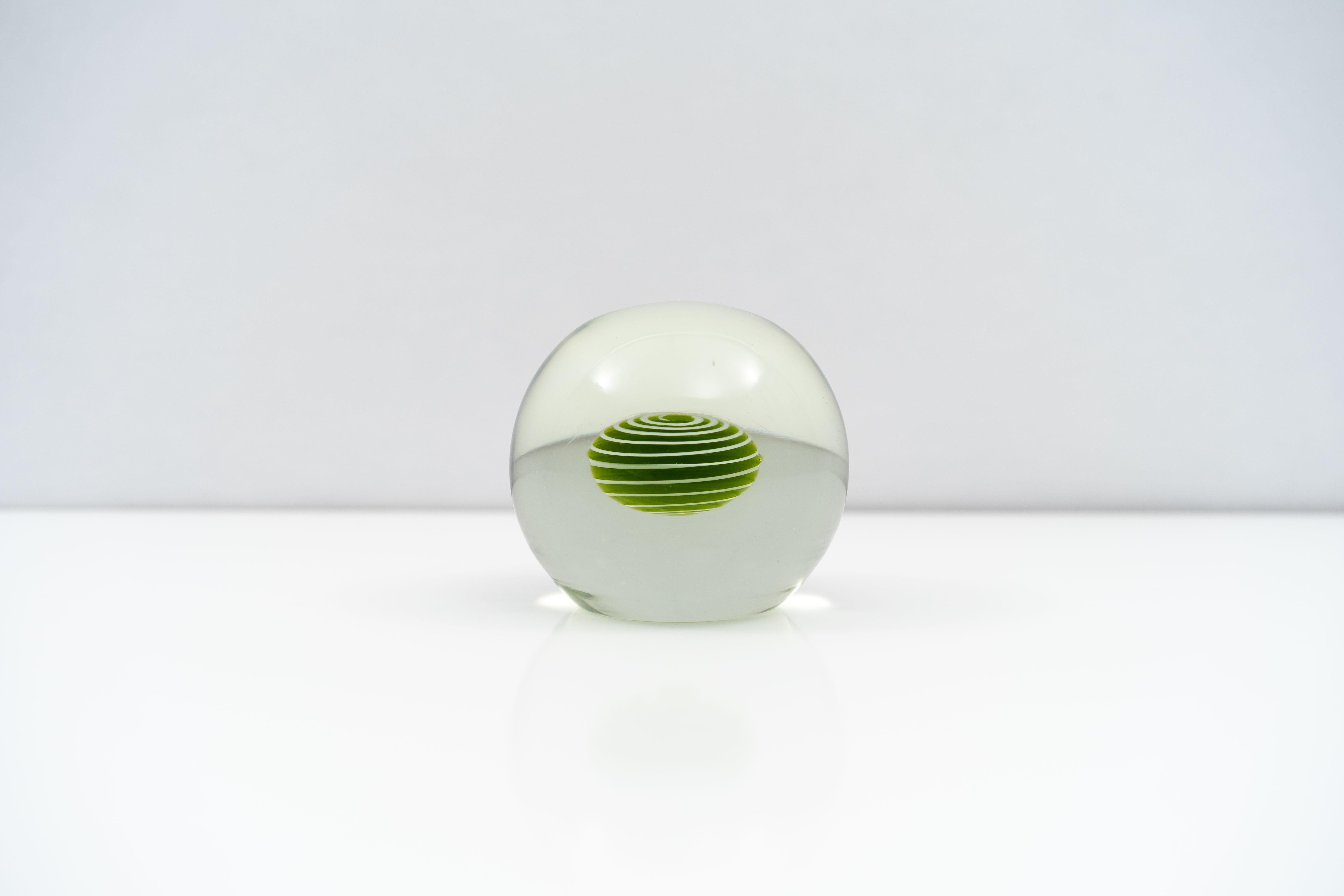 A substantial Salviati Murano blown glass paperweight, circa 1960. A green core accented with white swirls is suspended in the center of the piece. Original Salviati foil label affixed to underside.