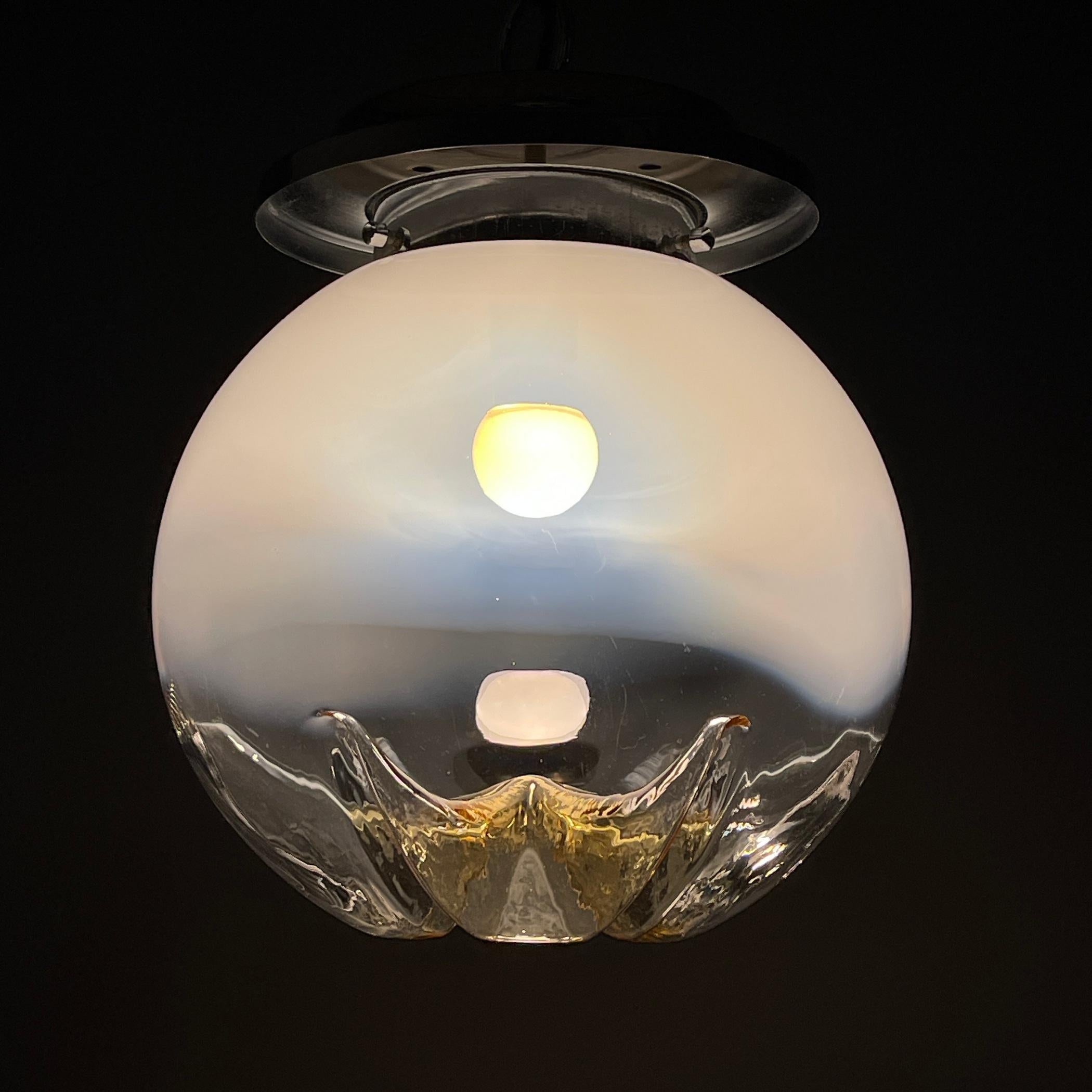 Indulge in the allure of this stunning Murano glass pendant lamp crafted by Mazzega during the remarkable 1960s in Italy. Adorn your home with a captivating piece that emanates the essence of vintage Italian charm. The gracefully sculpted design