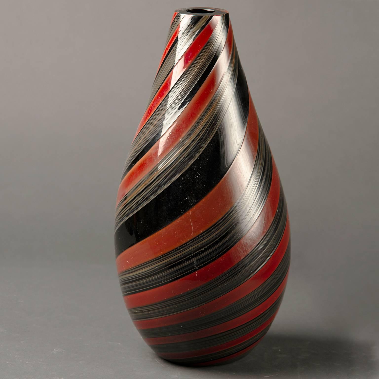 Signé Seguso Murano sur le dessous de la base, ce grand vase en verre lourd datant des années 1980 présente des rayures noires et rouges.
 