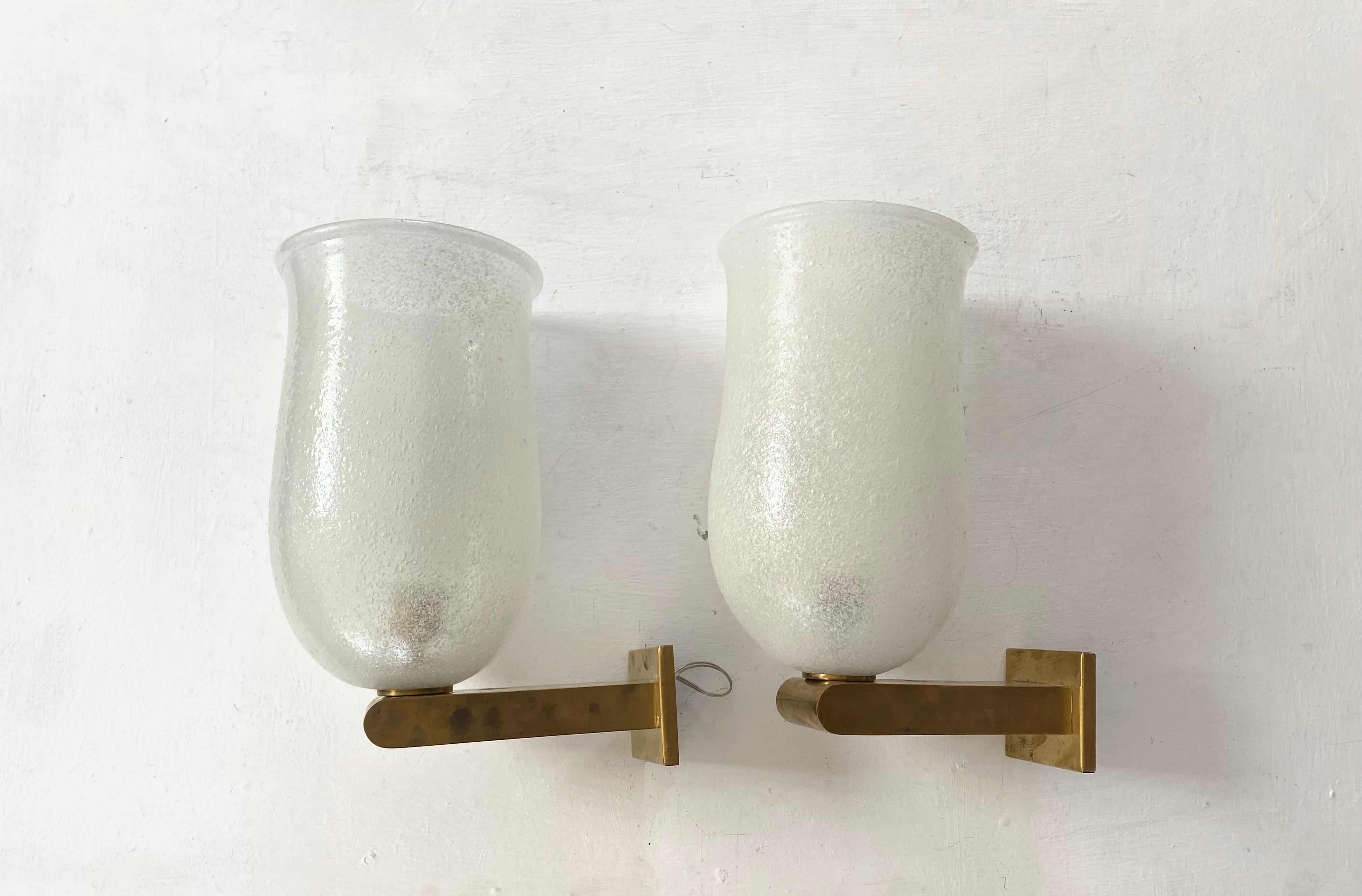 Large Murano glass sconces. 
The glass shade is manufactured in the Bollicine technique which was very characteristic of the Venini factory and their Art Deco era designs.
Each sconce holds one e27 bulb and has been recently rewired.
The brass can