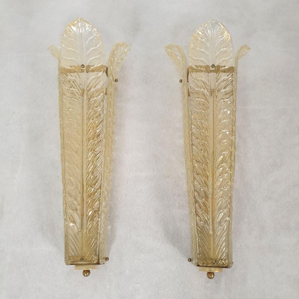 Pair of large Murano glass Mid Century Modern sconces, attributed to Barovier & Toso, Italy 1970s.
The vintage wall sconces are made of three tall gold flakes Murano glass leaves, over a brass frame.
The leaves are stylized. The Murano glass is