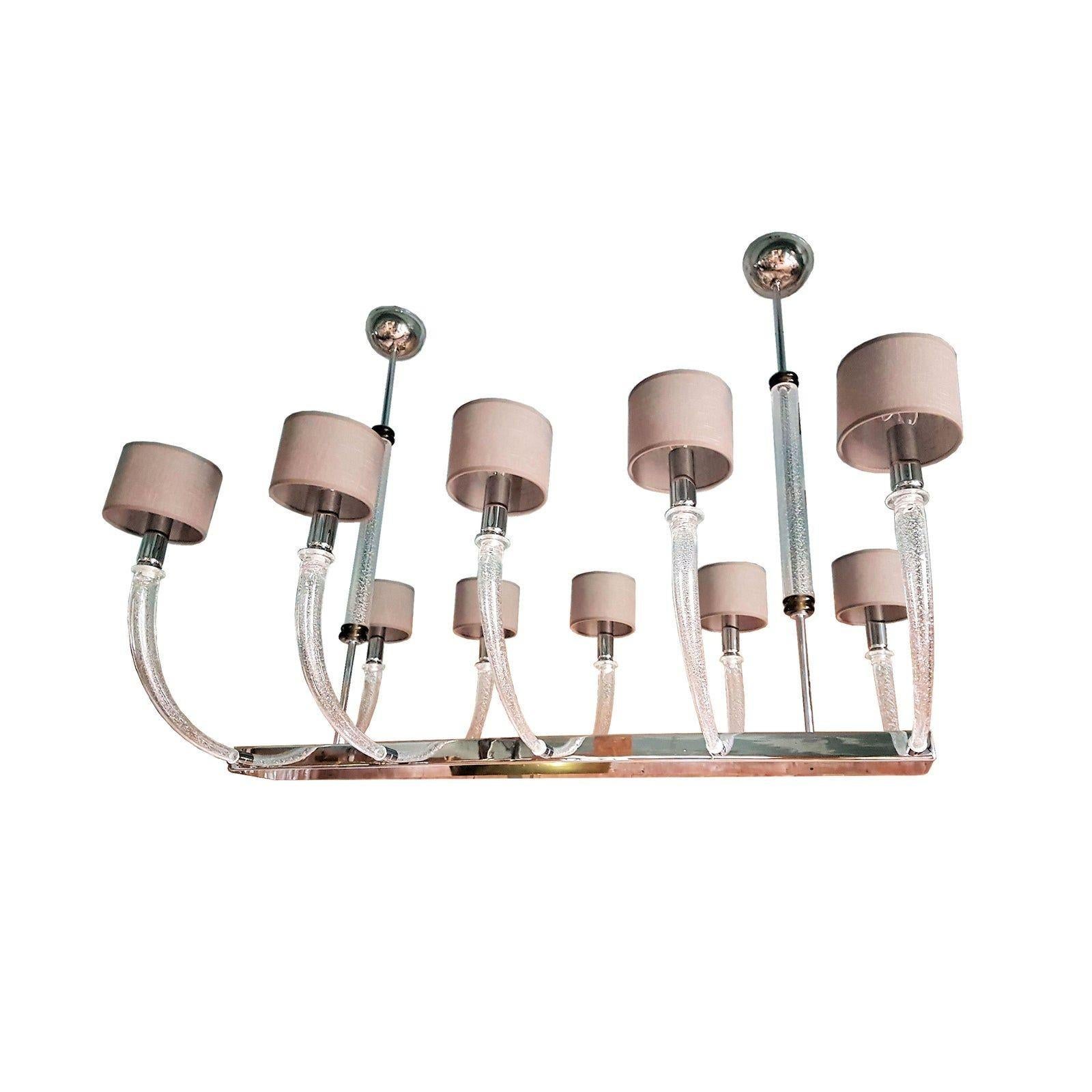 Grande lampadario allungato in vetro di Murano e cromo della metà del secolo scorso, con 10 luci.
Attribuito a Seguso, Italia, fine anni '70.
Bracciali in vetro trasparente di Murano soffiato a mano con inclusioni di foglie d'argento.
Il vetro di