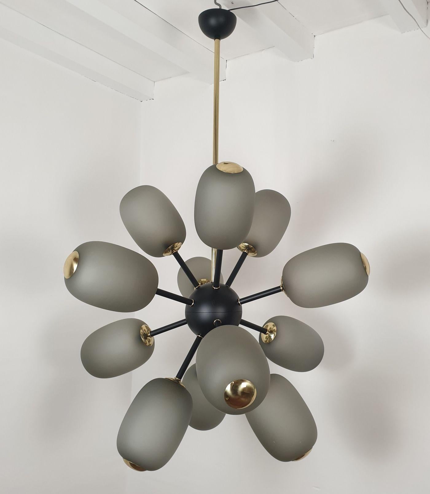 Very large Sputnik chandelier, attributed to Barovier and Toso, Italy 1990s.
The Mid-Century Modern chandelier is made of 12 light-grey Murano glass globes, a black painted frame, and brass elements.
It has 1 light in each glass: 12 total. Rewired