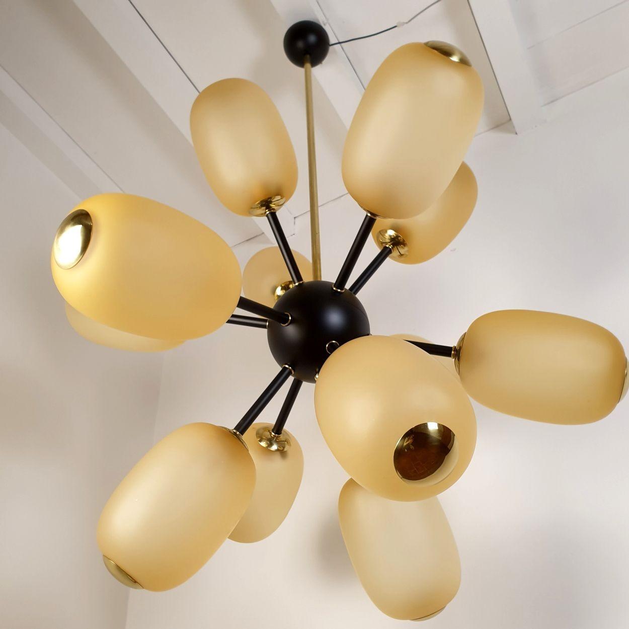 Sehr großer Sputnik-Kronleuchter, Barovier und Toso zugeschrieben, Italien 1990er Jahre.
Der Mid Century Modern-Kronleuchter besteht aus 12 bernsteinfarbenen Murano-Glaskugeln, einem schwarz lackierten Rahmen und Messingelementen.
Der italienische