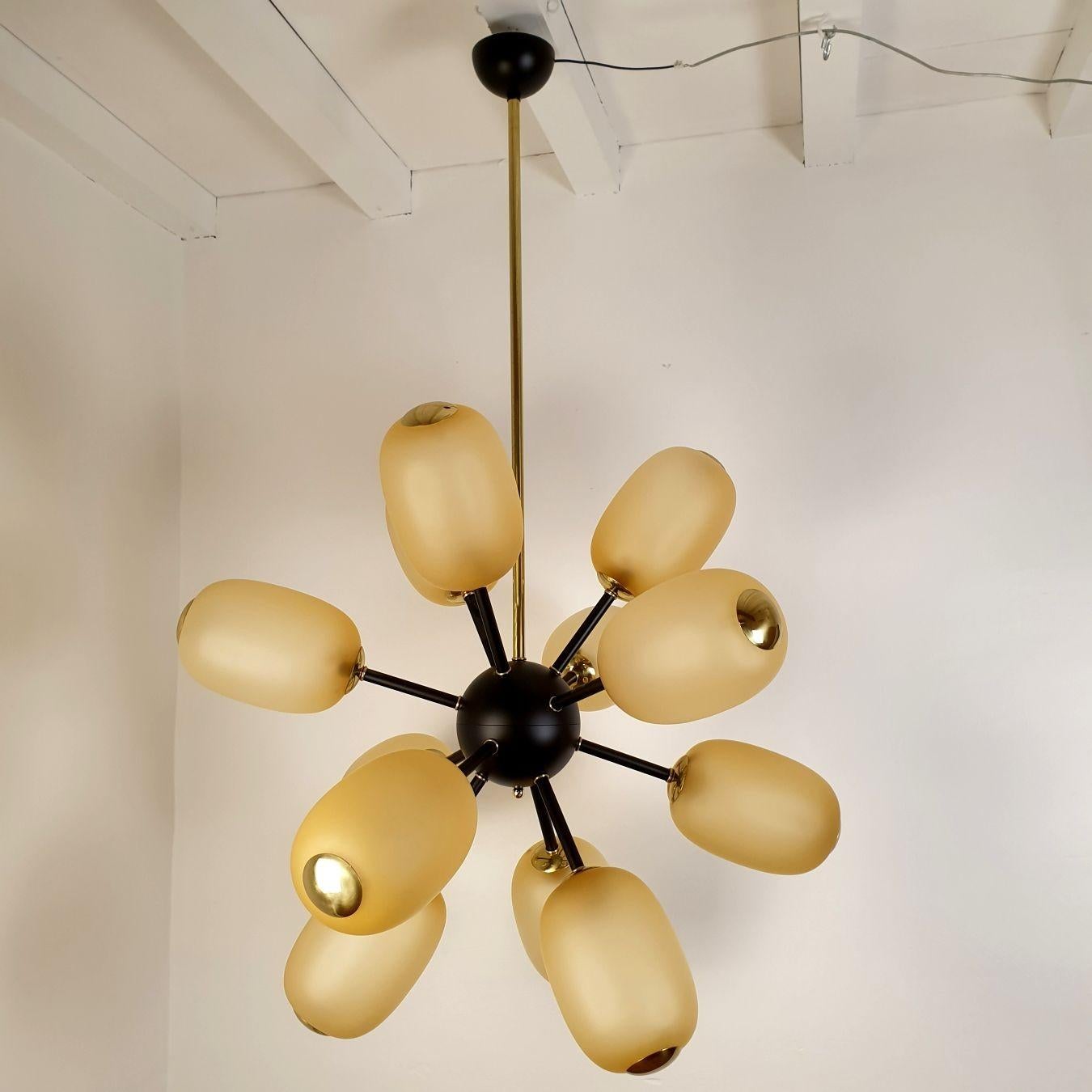 Lampadario Sputnik di grandi dimensioni, attribuito a Barovier e Toso, Italia anni '90.
Il lampadario Mid Century Modern è composto da 12 globi in vetro di Murano color ambra, una cornice dipinta di nero ed elementi in ottone.
Il lampadario italiano