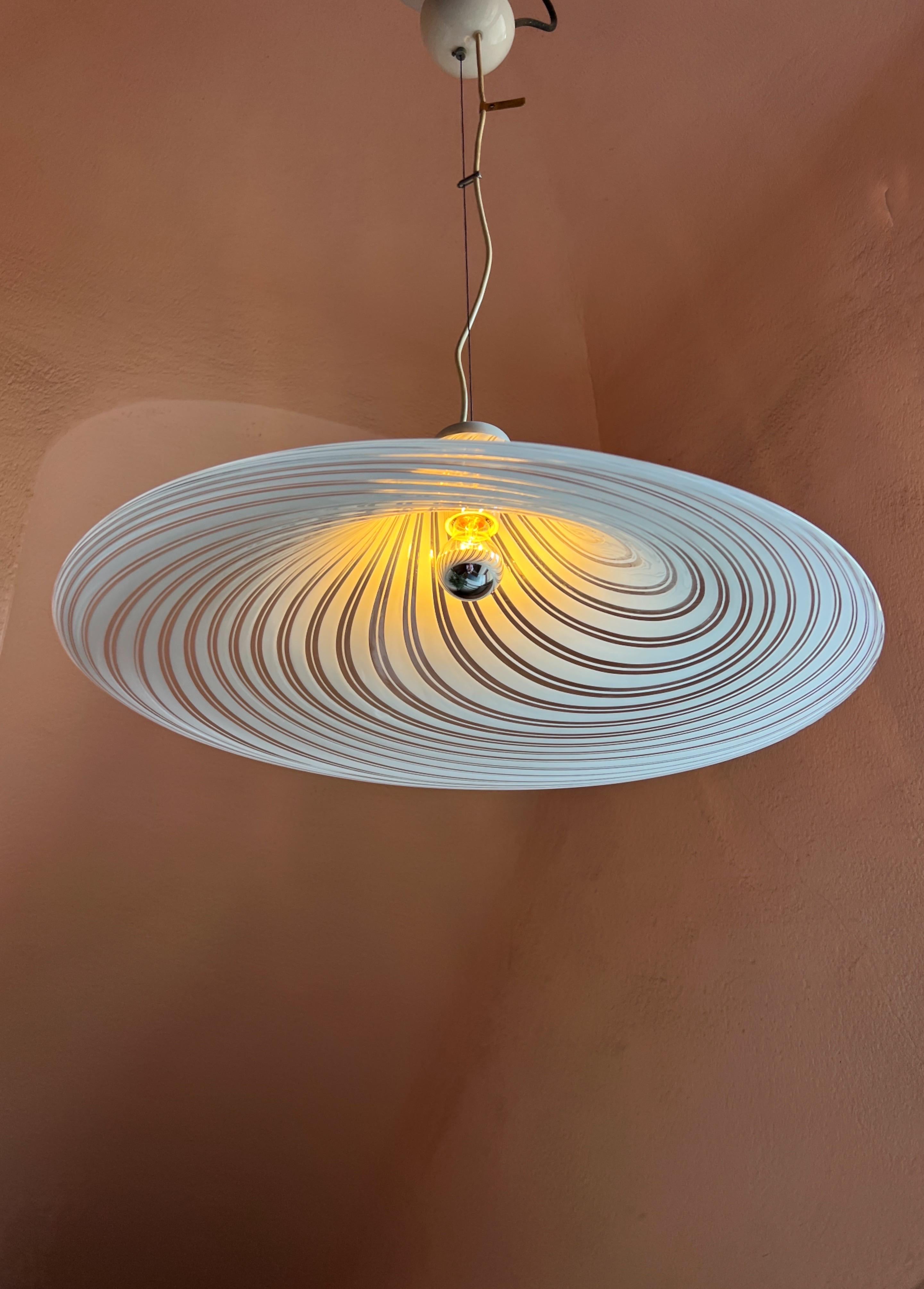 Grande plafoniera a volute in vetro di Murano bianco. Filo regolabile fino al soffitto. Conserva ancora la sua etichetta originale di F. Fabbian Murano. L'altezza con il filo regolabile è di 120 cm.
