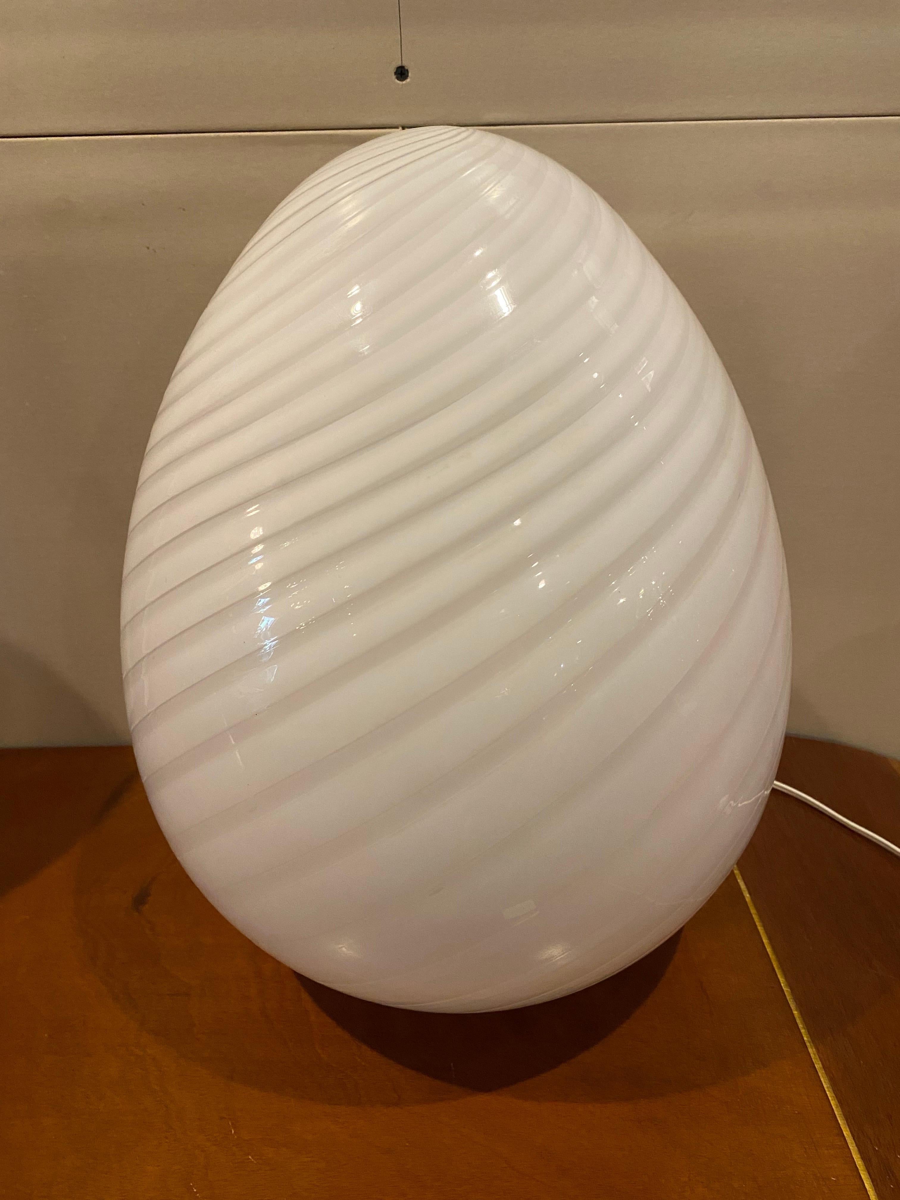 A beautiful Italian modern Murano glass table lamp by Vetri is hand-blown and features a swirl pattern that offers a nice glow when lit. This vintage table lamp is in great condition, Italy, circa 1970s.