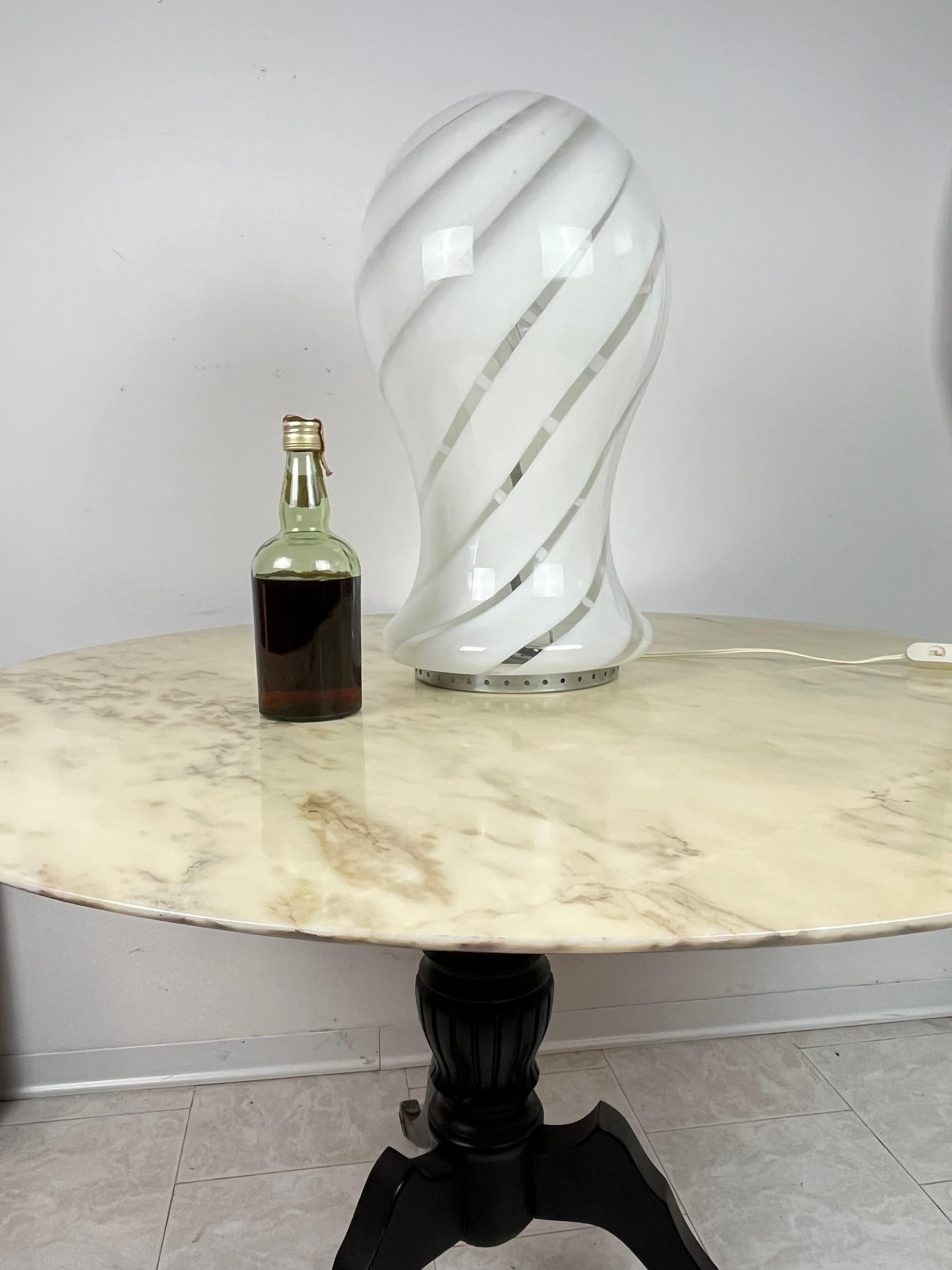 Grande lampe de table en verre de Murano, fabriquée en Italie, années 1970
Intacte et fonctionnelle, 55 cm de haut.
Fabrication artisanale, achetée à Venise.

Nous garantissons un emballage adéquat et nous expédions par DHL, en assurant le contenu