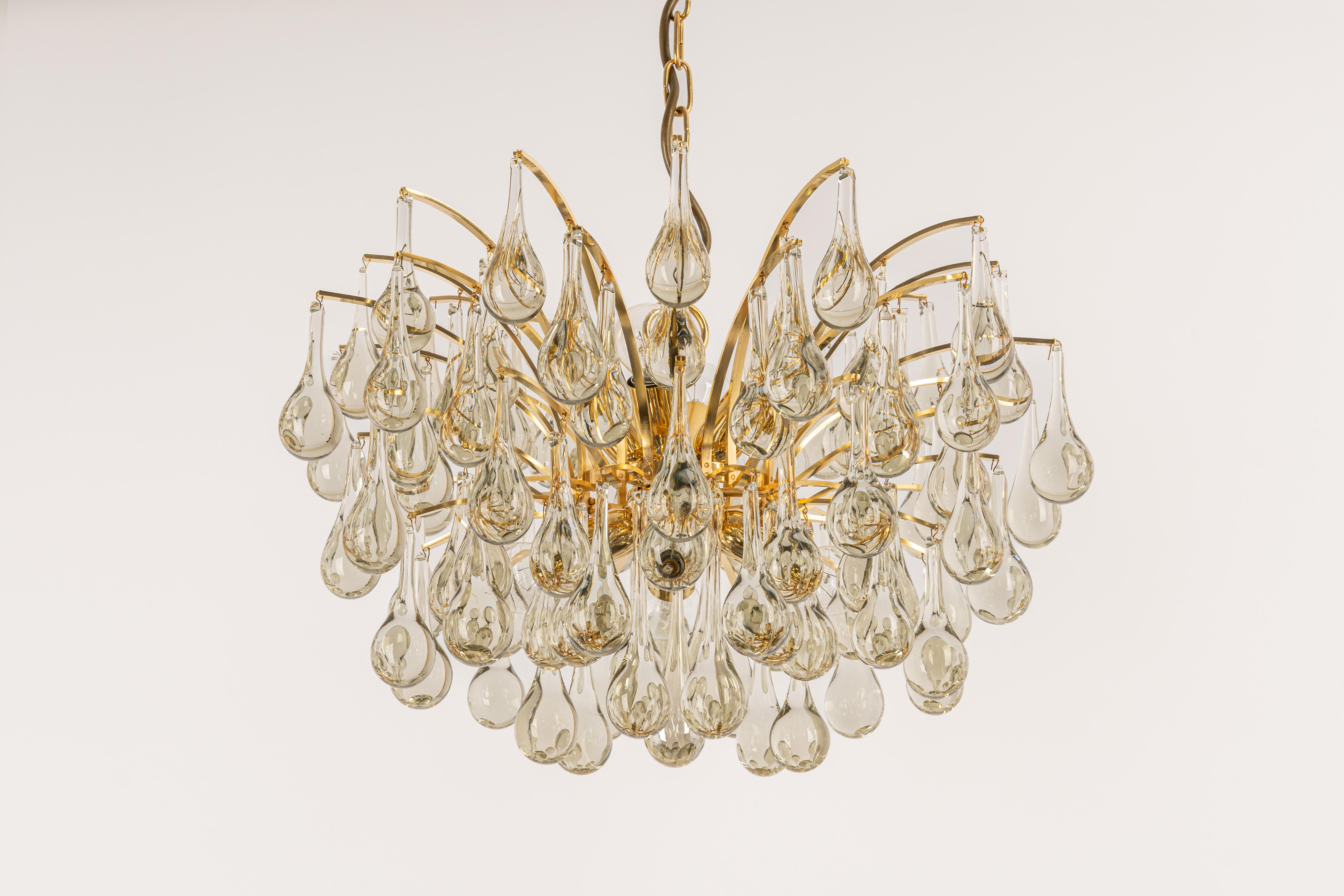 1 of 2 Stunning chandeliers by Christoph Palme, Germany, manufactured in the 1970s. It’s composed of Murano teardrop glass pieces on a gilded brass frame.

High quality and in very good condition. Cleaned, well-wired, and ready to use. 

The