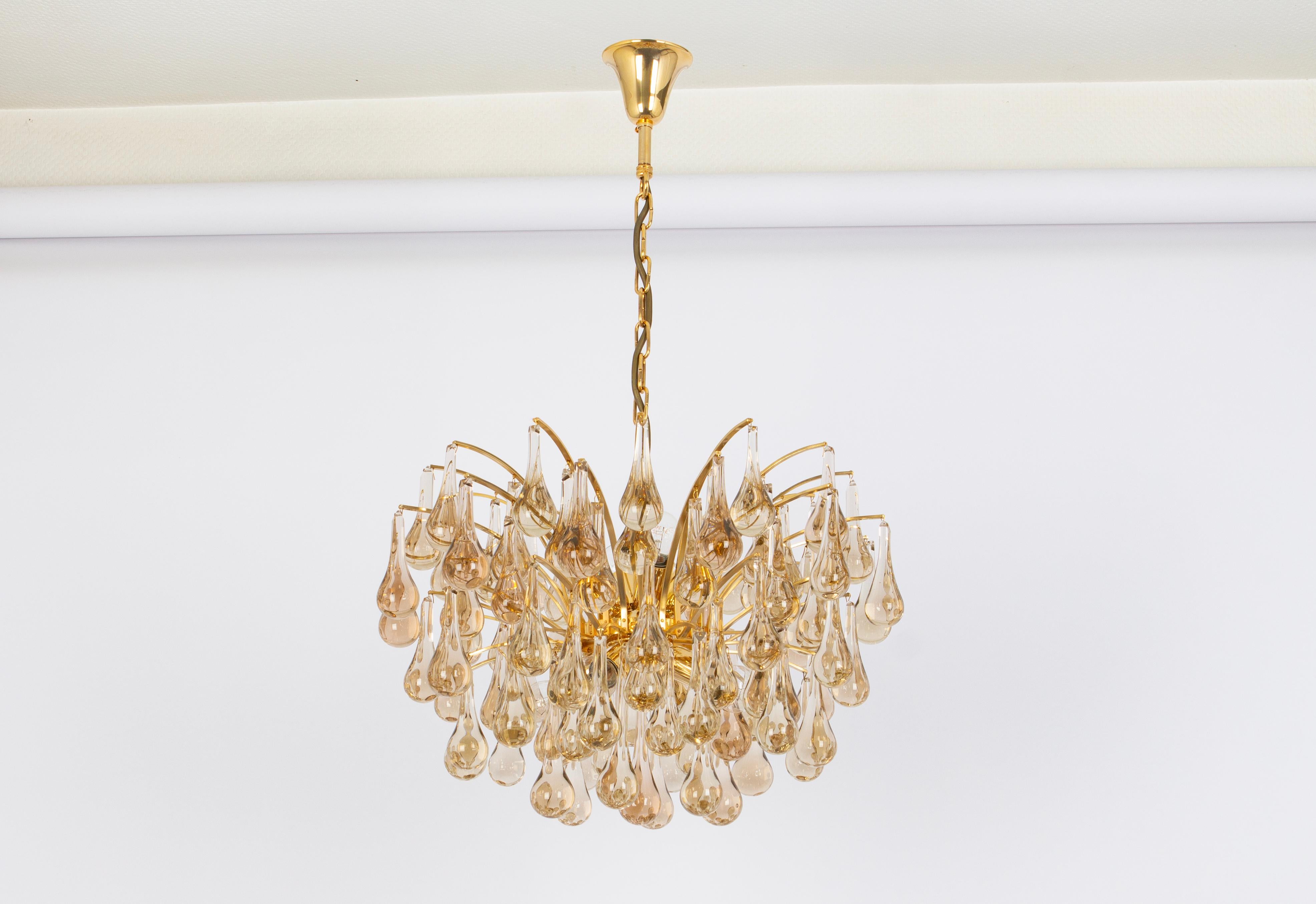 1 of 2 Stunning chandeliers by Christoph Palme, Germany, manufactured in the 1970s. It’s composed of Murano teardrop glass pieces on a gilded brass frame.

High quality and in very good condition. Cleaned, well-wired, and ready to use. 

The fixture