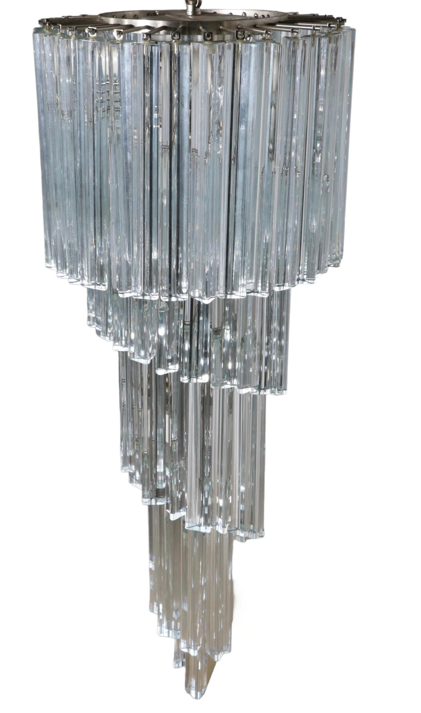 Spectacular glass chandelier of descending spiral form, having solid glass triangular ( triedi )  prisms. The fixture was produced in Italy, and this model is often attributed to Venini.
This example is in very good, original, clean and working
