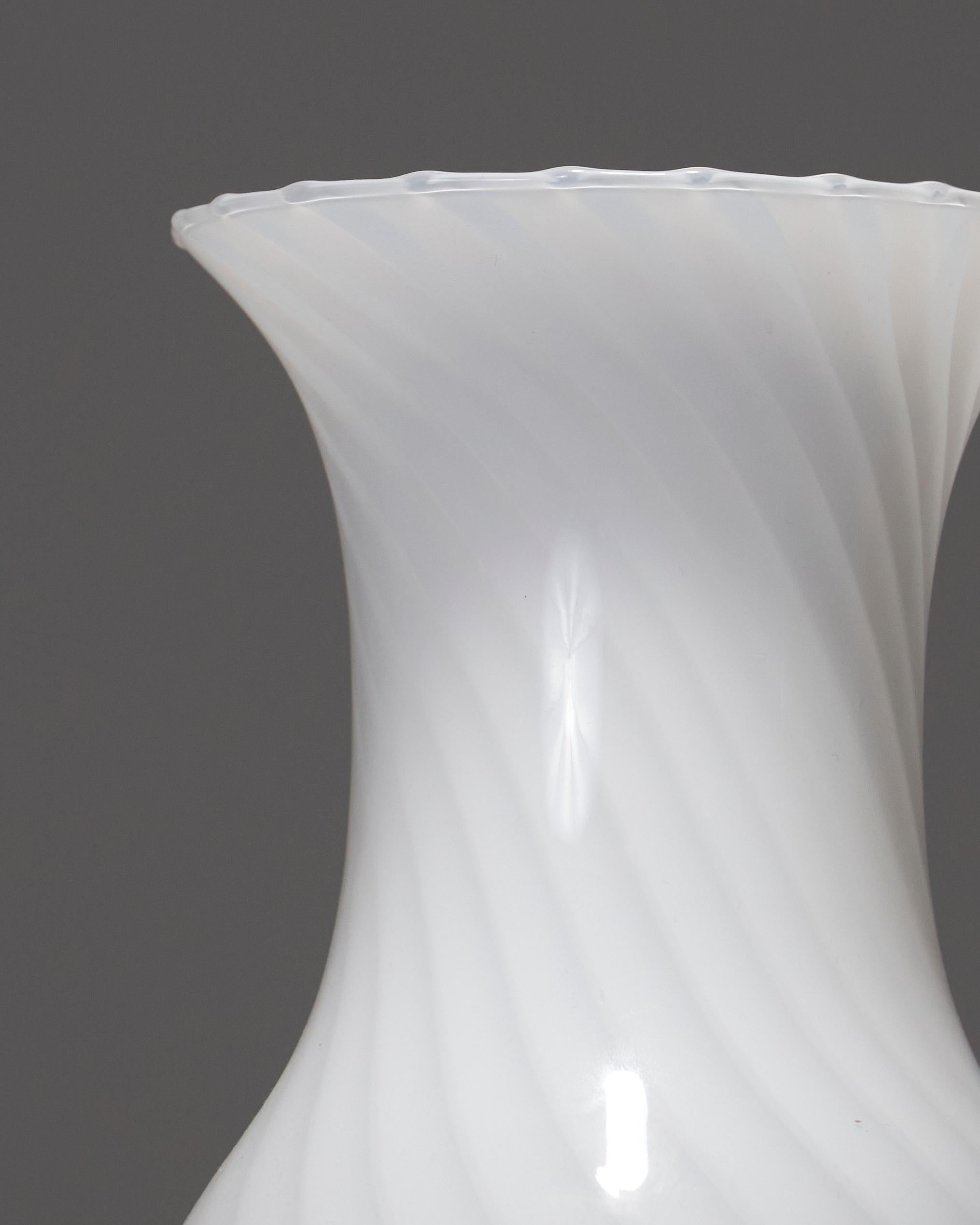 Questo vaso bianco di Murano Vetri Swirl degli anni '60-'70, realizzato in vetro soffiato, riflette la purezza e l'eleganza del design del vetro di Venezia. La sua forma fluida e le sottili spirali lo rendono un pezzo unico, che unisce
