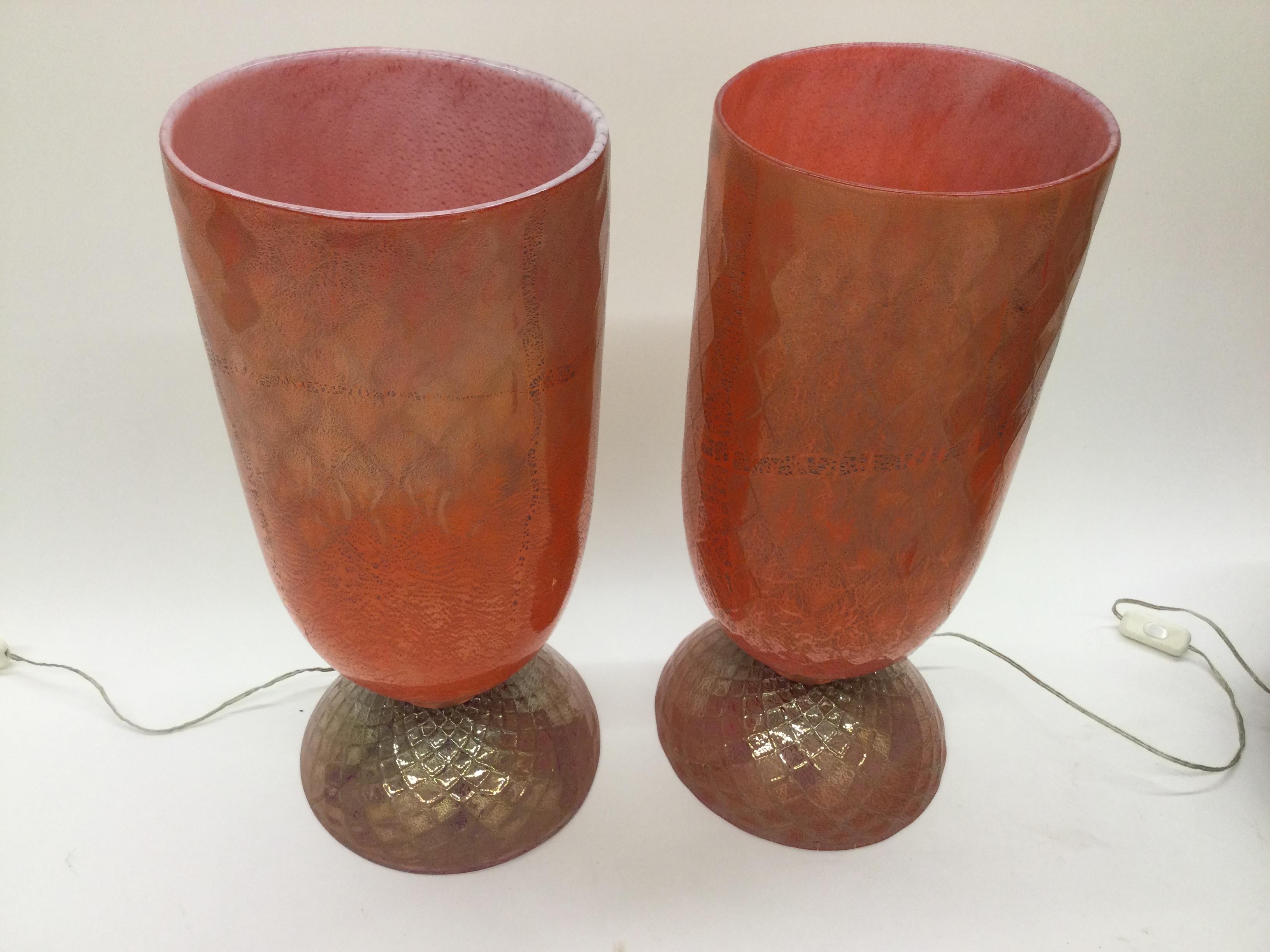 Amazing pair of Murano urn form lamps in vibrant red with silver foil decoration. Waffled design in the glass makes these lamps very rare and desirable.