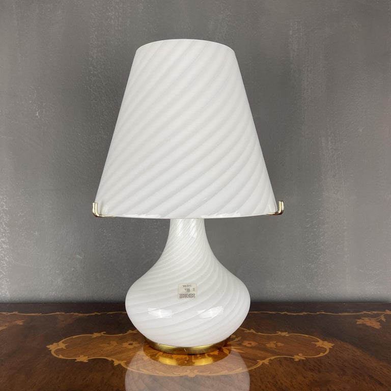 Large classic mushroom swirl Murano glass table lamp made in Italy in the 1970s. The beauty of the classic swirl glass makes this lamp a pleasure to look at. It has two light bulbs above and one light bulb in the base. Upper and lower bulbs can be