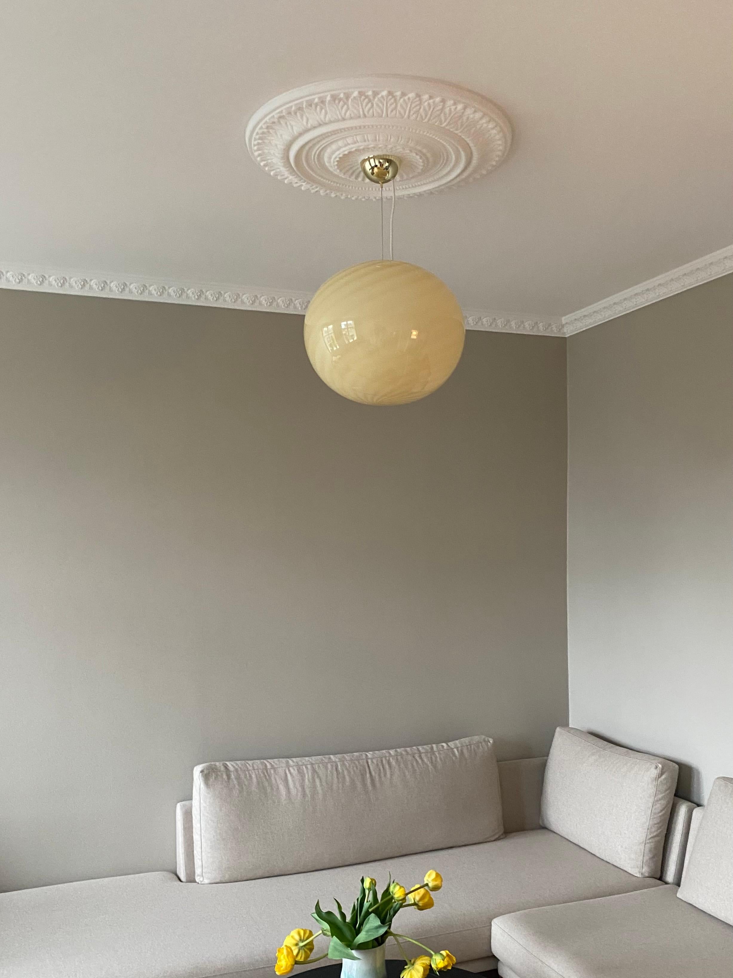 Large new Italian Murano candy pendant ceiling lamp in a beautiful soft yellow shade. Mouth-blown glass in oval shape with swirl pattern. E27 socket. Comes with adjustable suspension 
Handmade in Italy.
D:40 cm  

As it is mouth blown glass, the