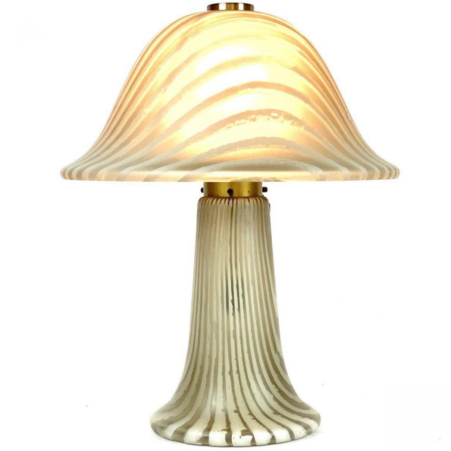 This unique Mid-Century Modern table lamp from the 1970s was designed by Peill & Putzler. It has a mushroom design made of hand-blown Murano glass and brass fixture. The glass was made to show its beautiful form. Both the colors of soft satin glass
