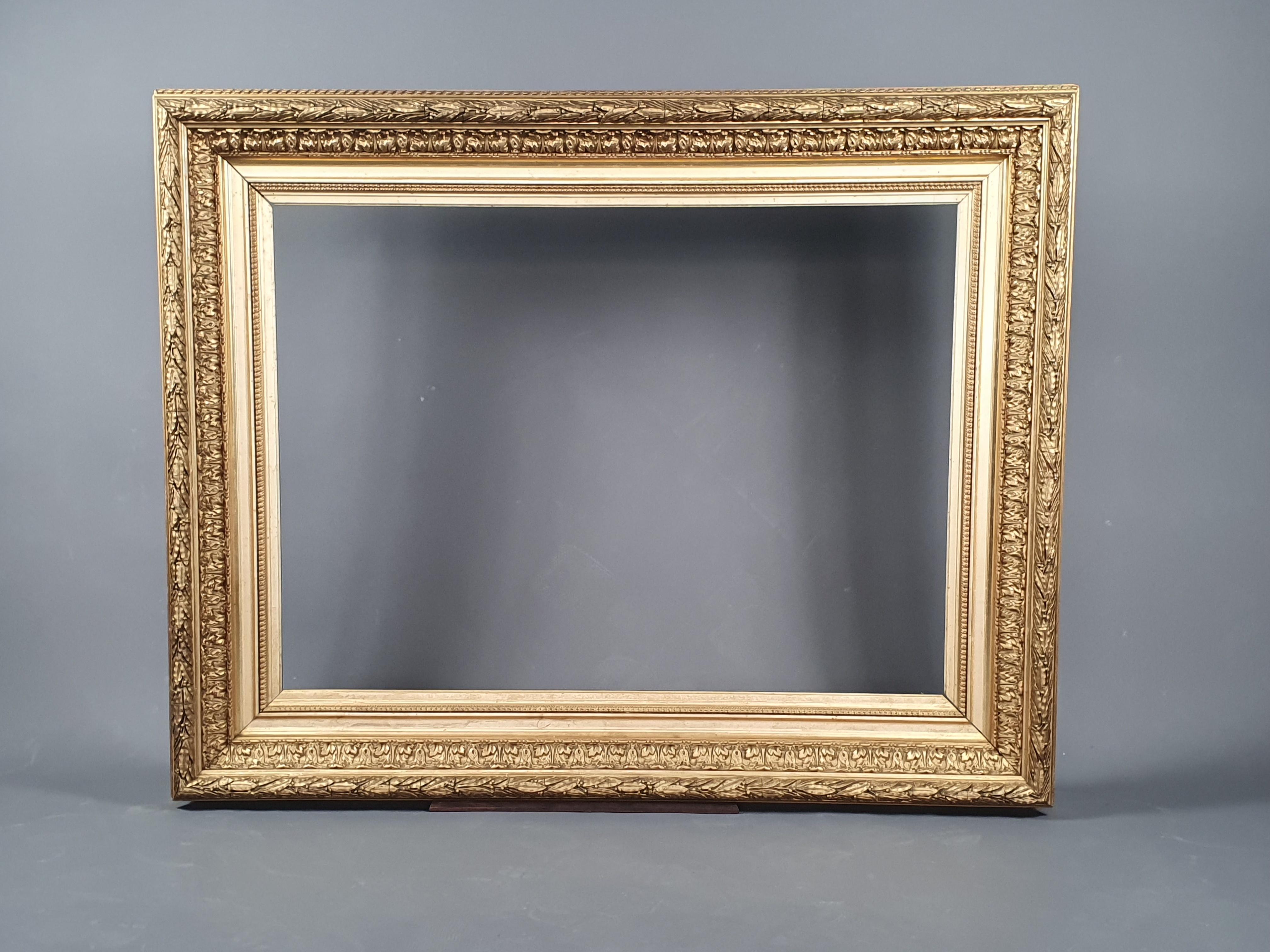 Large Napoleon III frame in wood and gilded stucco with rich decoration of successive friezes of gadroons, foliage, pearls, .. alternated by gilded leaf strips and polished with agate stone.

Work from the second half of the 19th century.

Very