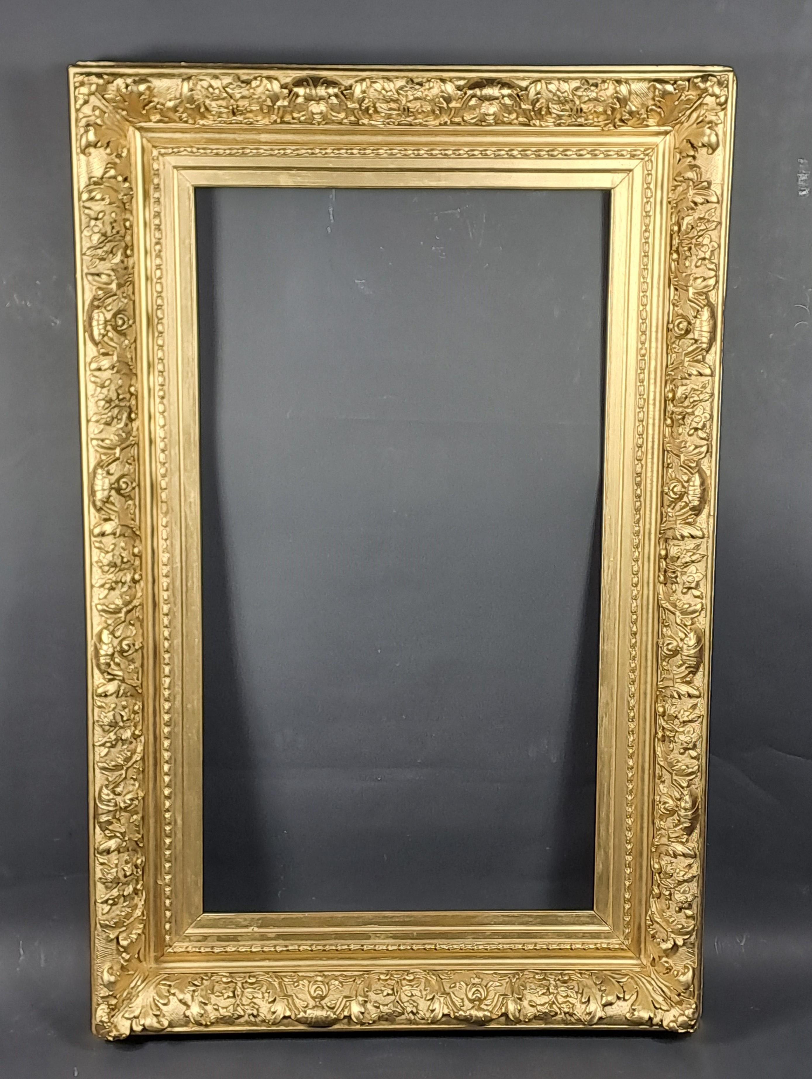 Gran marco Napoleón III de madera y estuco dorado con rica y generosa decoración de follaje y flores.   

Muy grueso y sólido.   

Obra francesa de la segunda mitad del siglo XIX.   

Muy buen estado, dorado de nuevo.   

Dimensiones totales: 150 CM