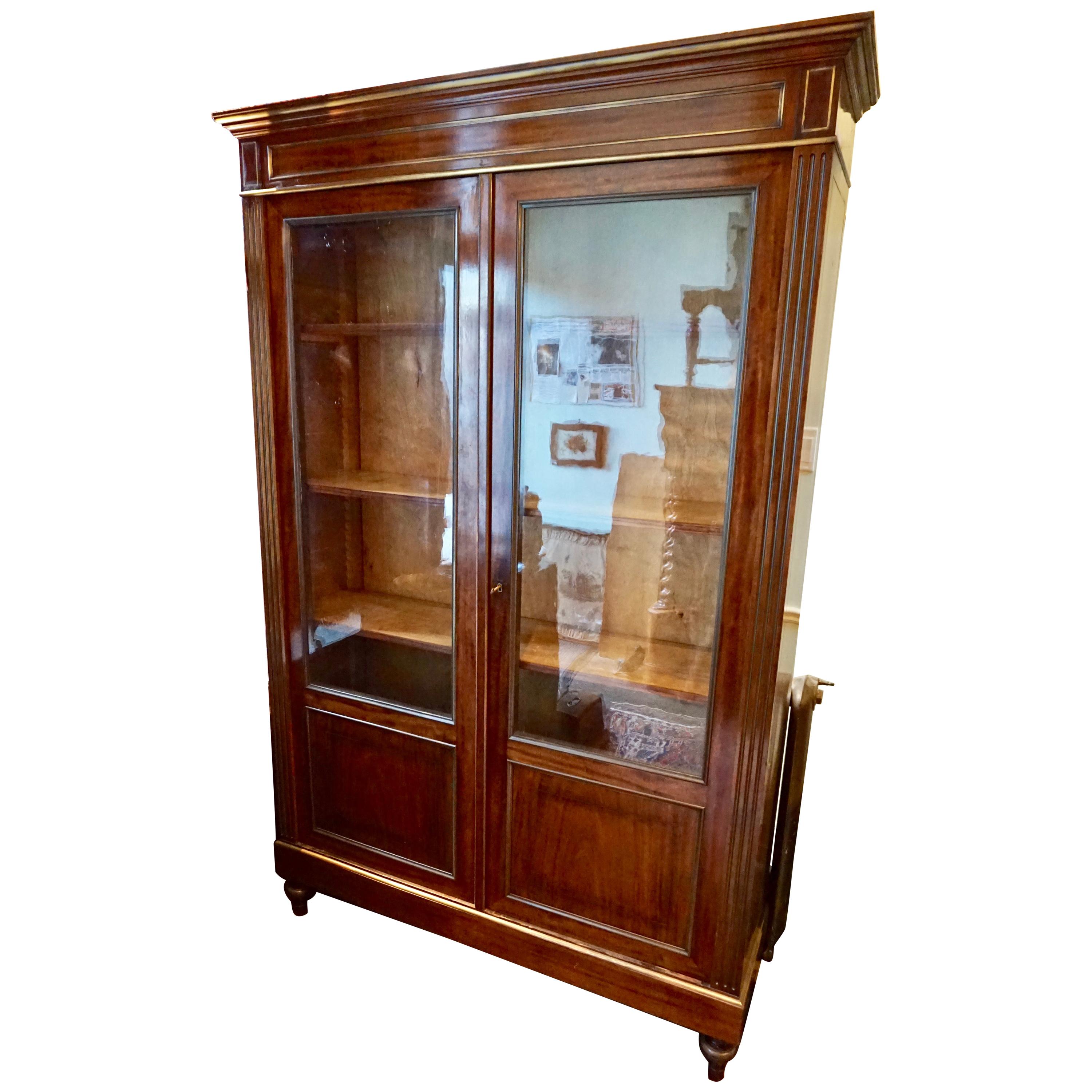 Circa 1850-60

Handsomely designed solid Mahogany Cabinet with Brass Inlay and surround. Beautiful patina, details and finesse abound this magnificent high quality bookcase cum showcase curio cabinet. Sits on bun feet. Adjustable shelves. Back