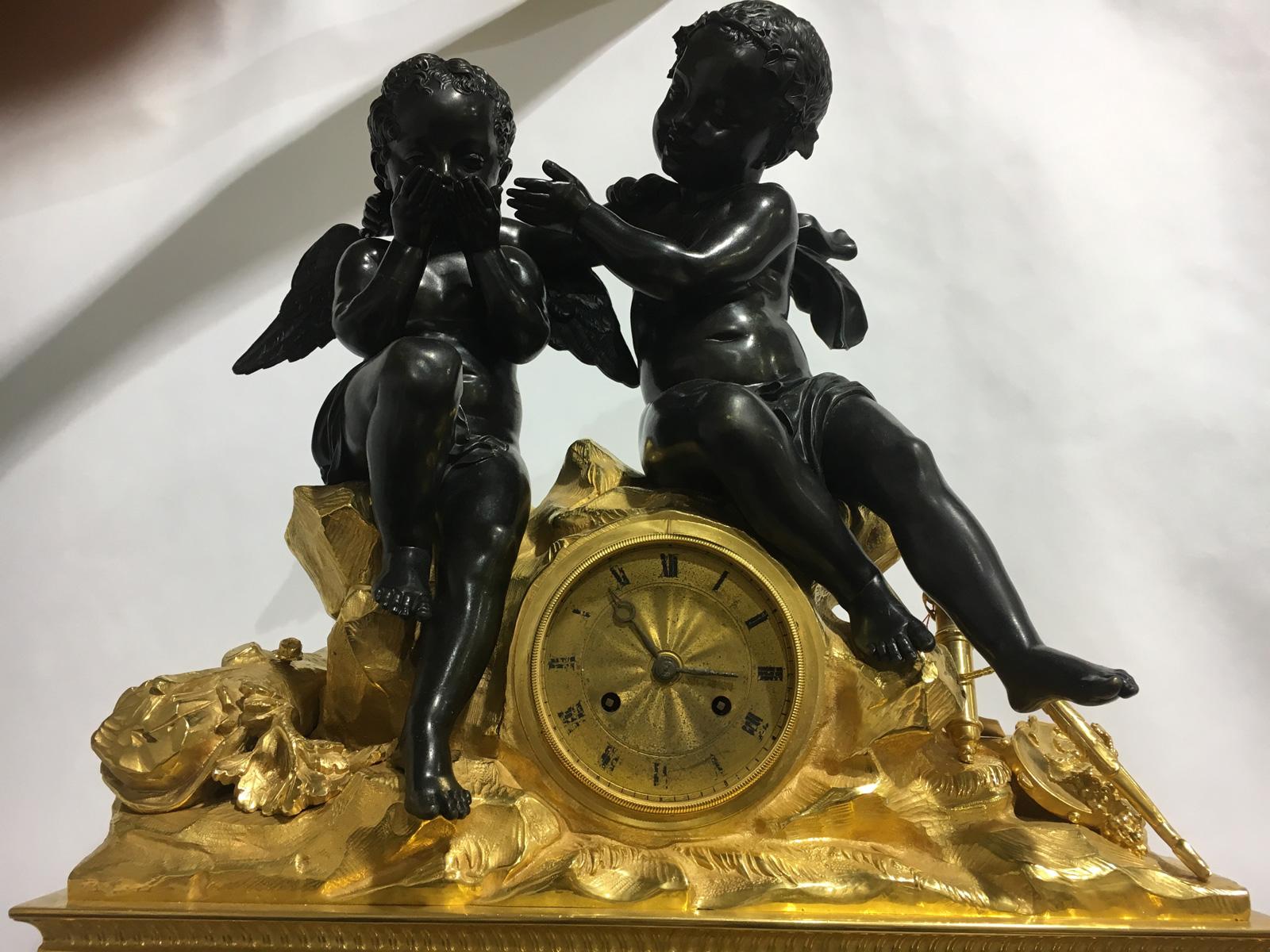 Charming Napoléon III mantel clock composed of two putti in patinated bronze sat on the clock and a rectangular marble base with scrolls and garland of flowers.
