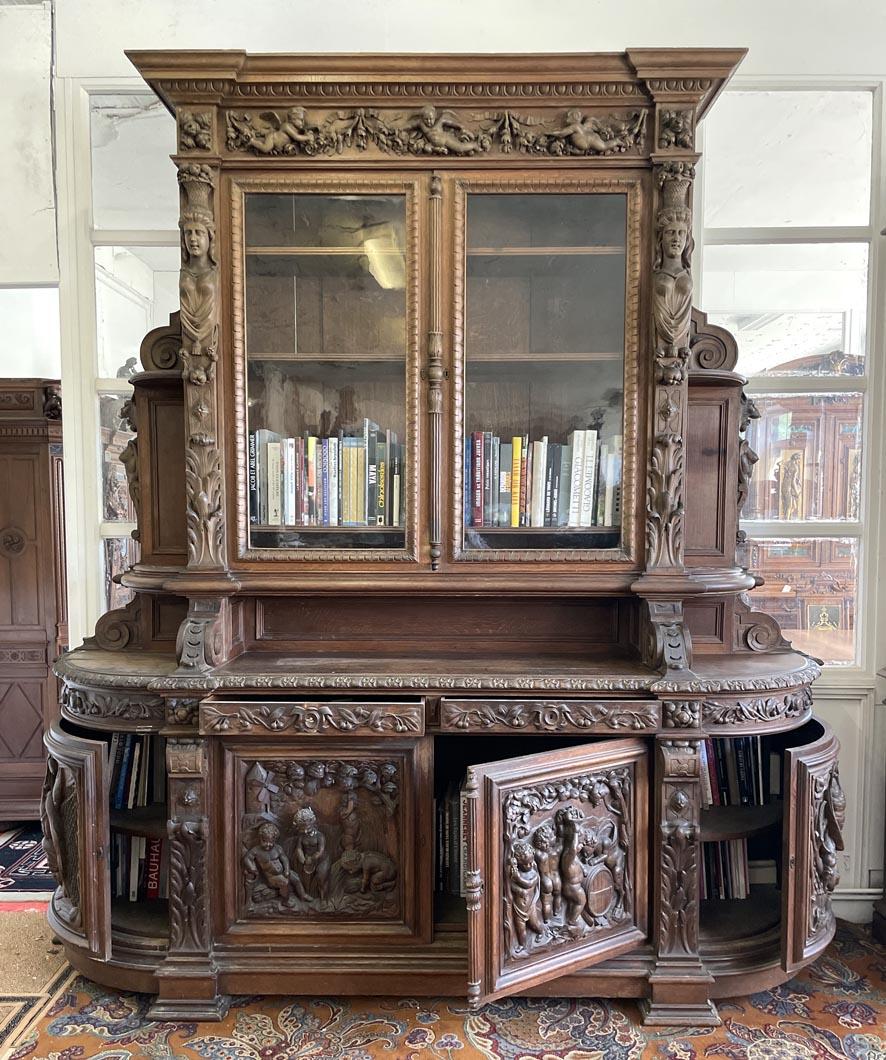 Impressionante libreria in rovere in stile Napoleone III, riccamente intagliata con il tema allegorico delle Four Seasons. Le porte inferiori presentano pannelli ad alto rilievo con figure di cherubini che raffigurano scene stagionali: vendemmia,