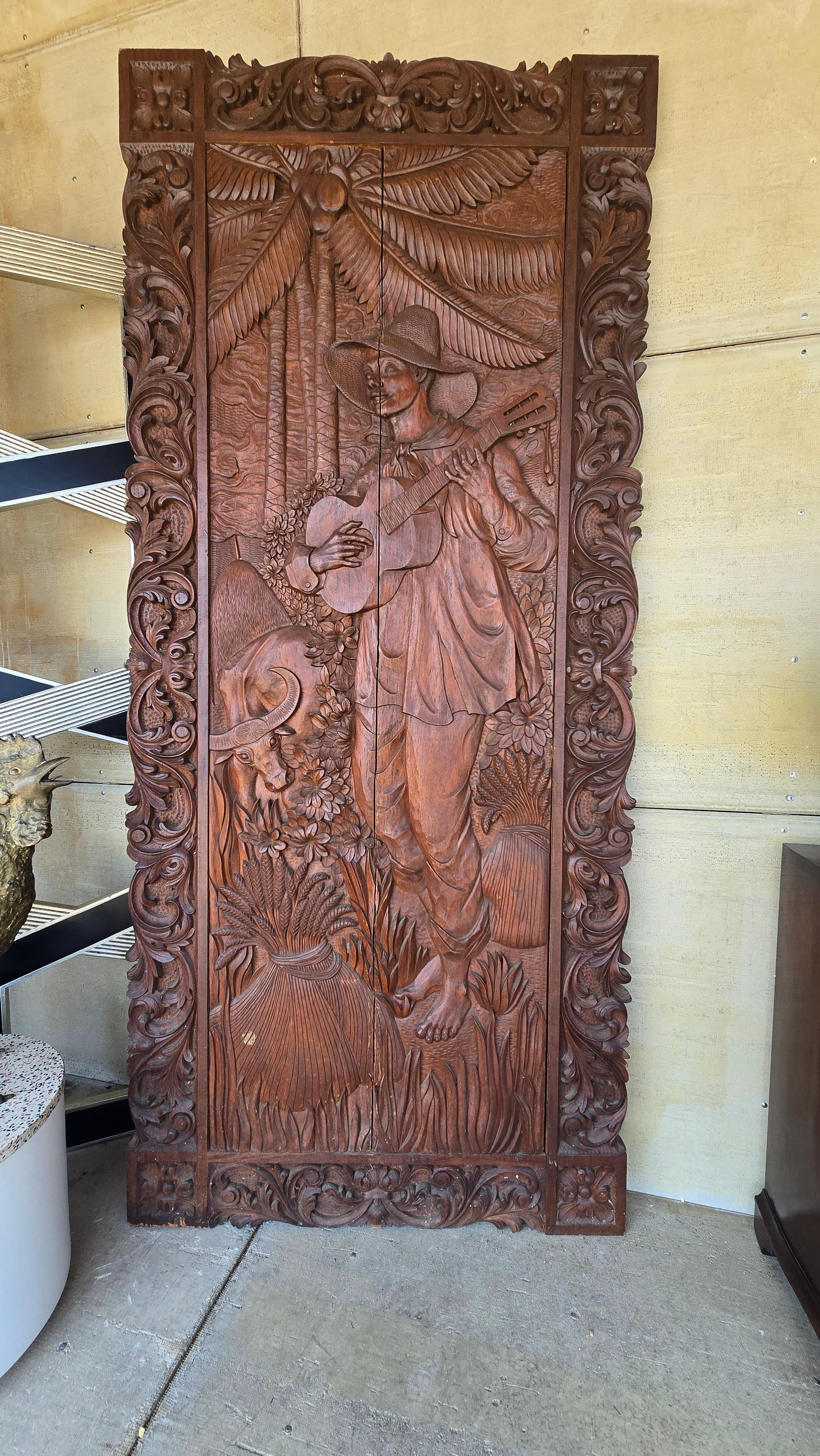 Un pannello monumentale intagliato in legno massiccio di Narra, attribuito a José P. Alcántara, uno dei più celebri intagliatori del XX secolo e figura venerata nelle Filippine, dove è riconosciuto come tesoro nazionale. Le opere di Alcántara
