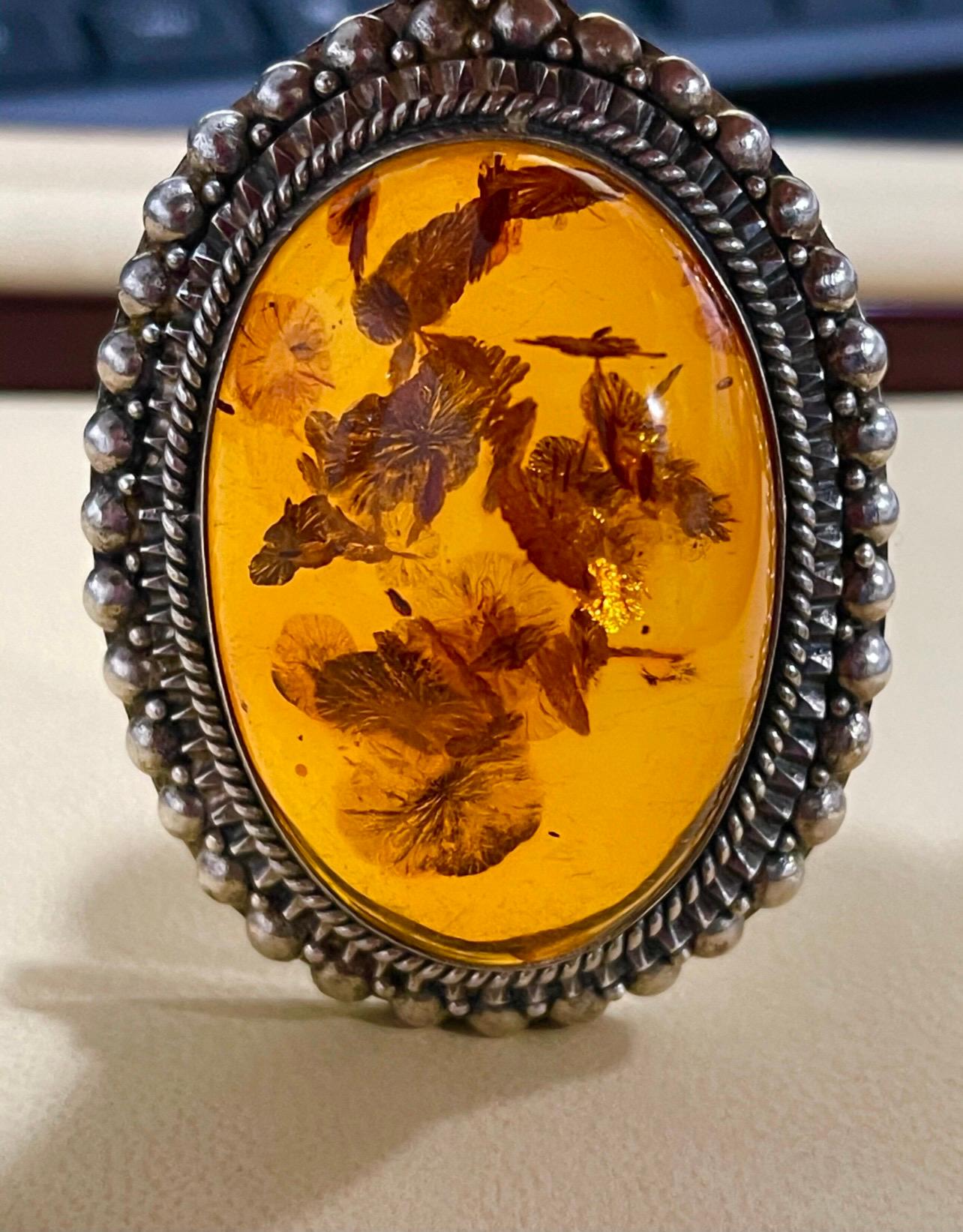 Approximately 200 Ct Natural Amber  Necklace / Pendant  surrounded by sterling silver 

Beautiful intense color Of amber
It has a bail for chain . No chain with the pendant. It has a large bail so one can put an omega chain or even a pearl