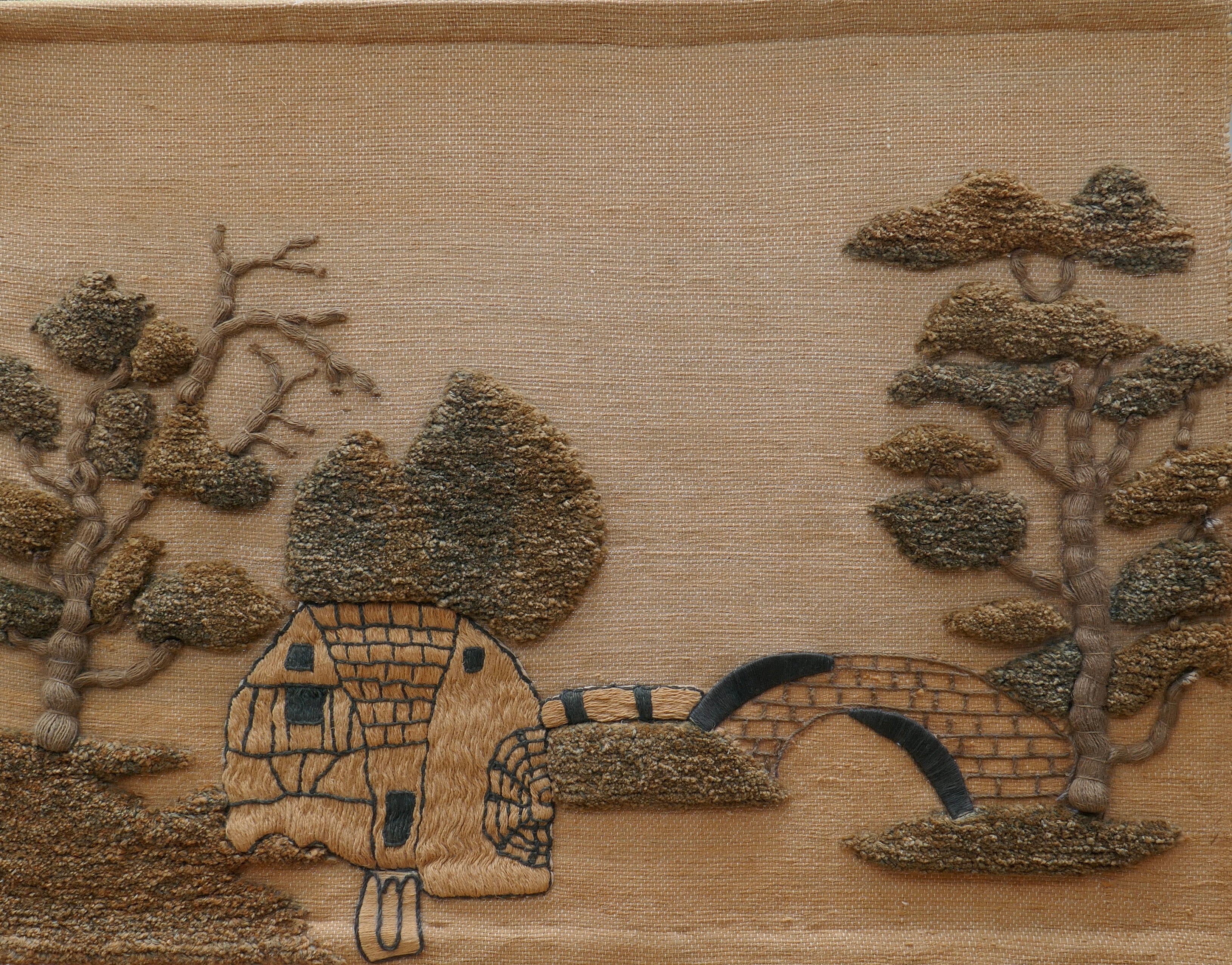 A large tapestry representing a landscape. The bottom of the canvas is jute. Natural fibre patterns representing a house with a pond and trees, in a Japanese style.
This fantastic wall hanging is one of the best examples of the textile art designed