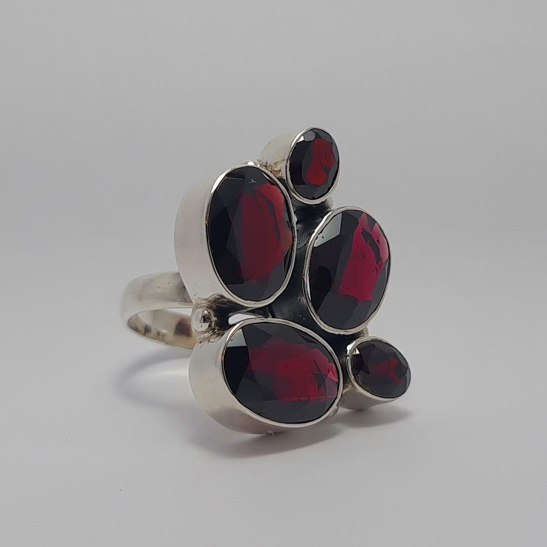 925 Sterling Silver Ring with large natural Garnet Gemstones
The ring size is 8 3/4 US

The size of the Large Oval shape Garnet stones is 10x14 mm.
The size of the Small Oval shape Garnet stones is 6x8 mm.
The Total weight of Garnet gemstones is 21