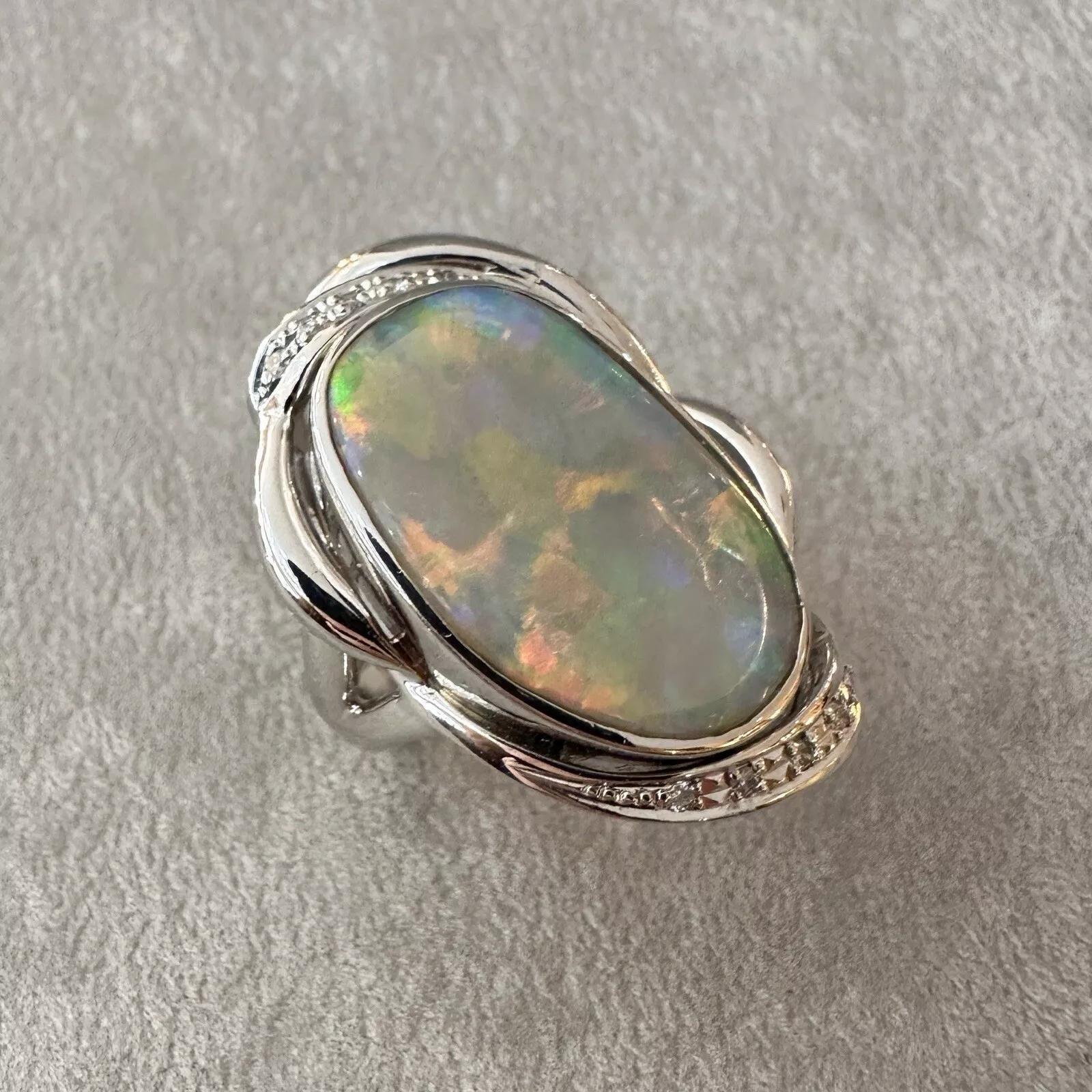 Large Natural Opal 6.81 carat and Diamond Ring in Platinum 

White Opal and Diamond Ring features a natural White Opal with Oblong shape and with a play of orange, blue, and green, accented Natural Round Diamonds and all set in Platinum.

Total