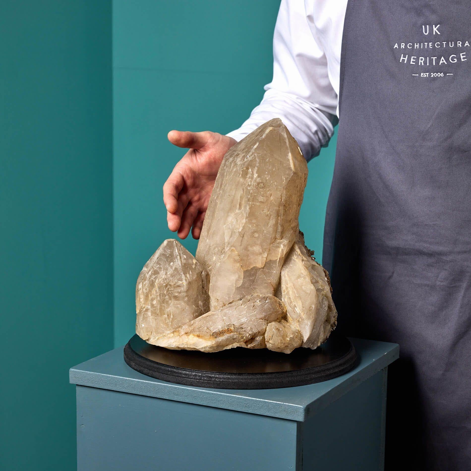A large quartz specimen sourced from an ex historic UK private collection.

Formed over millions of years, this unique and impressive specimen showcases a pleasing smokey cluster accompanied by quartz mica crystals to the reverse displaying a