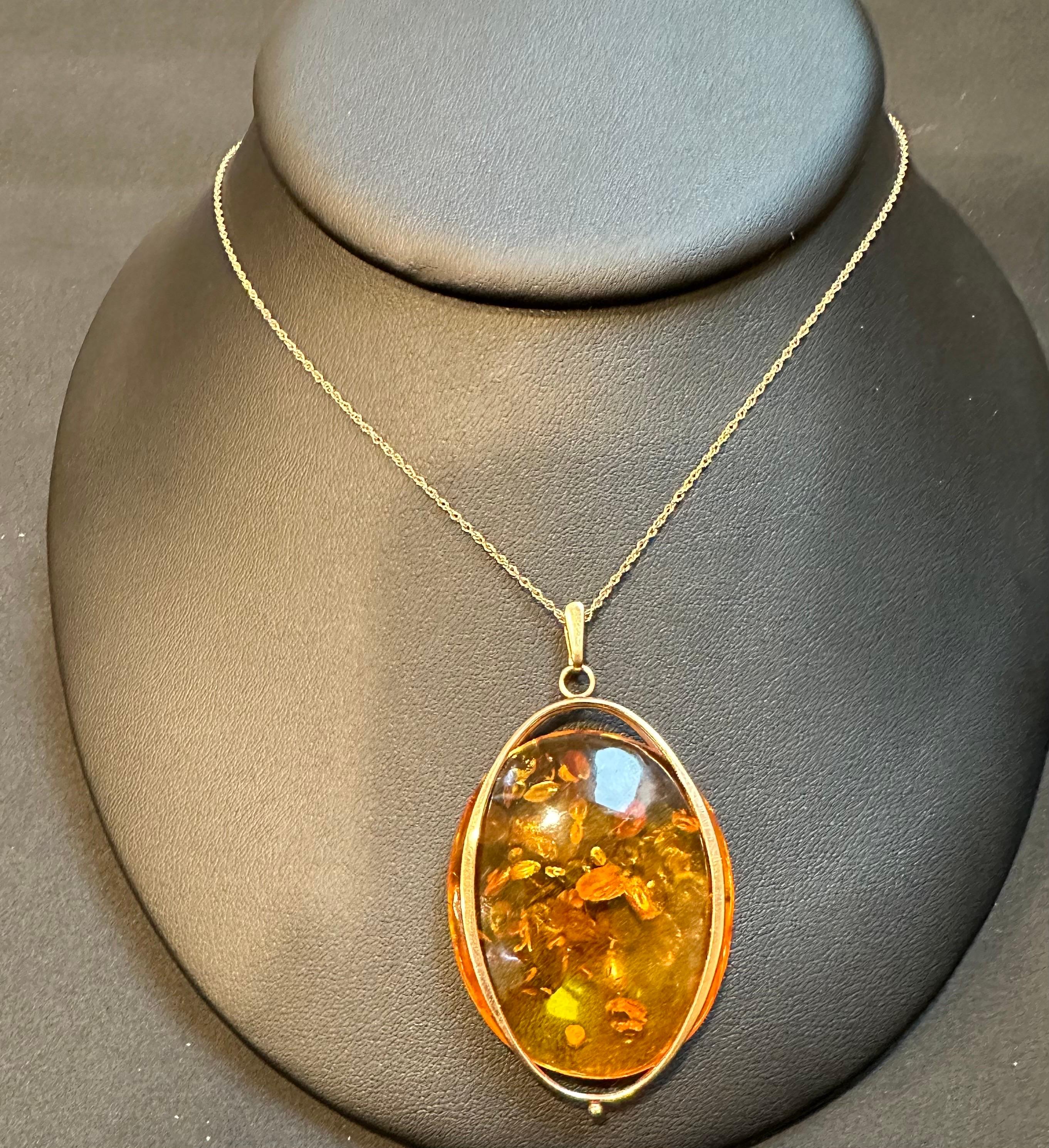 This Large Natural Russian Amber Necklace or Pendant in 14Karat Yellow Gold + Chain is a beautiful piece of jewelry that showcases the intense color of amber. The pendant features a bail for a chain and comes with a beautiful 16-inch long chain.