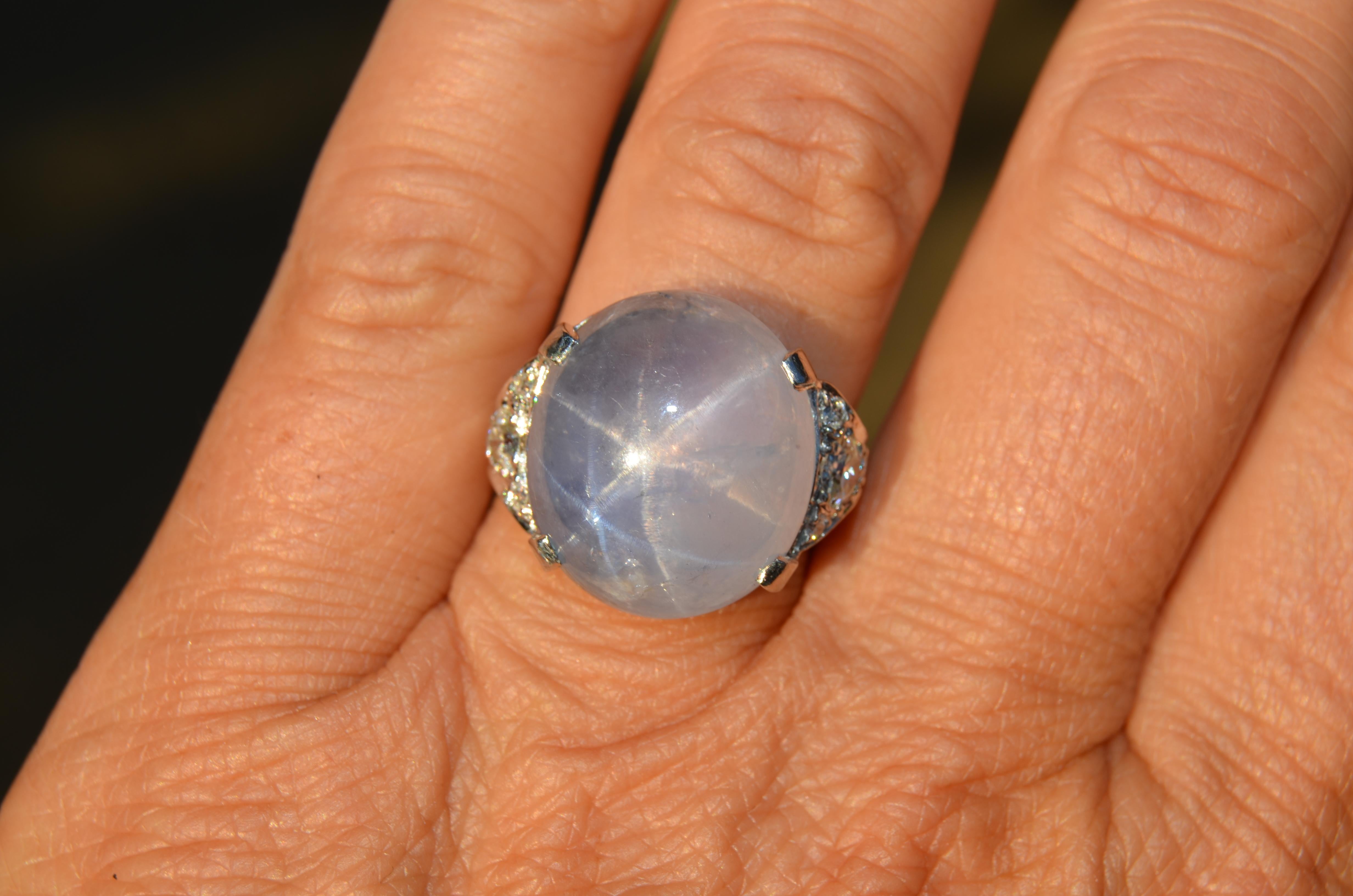 This is a big gumdrop of a ring...... It is crafted from 14K white gold dating from the 1930s/40s. The center stone is a large natural untreated star sapphire. The sapphire measures in at a bit over 23 carats in its prong setting. The color of the