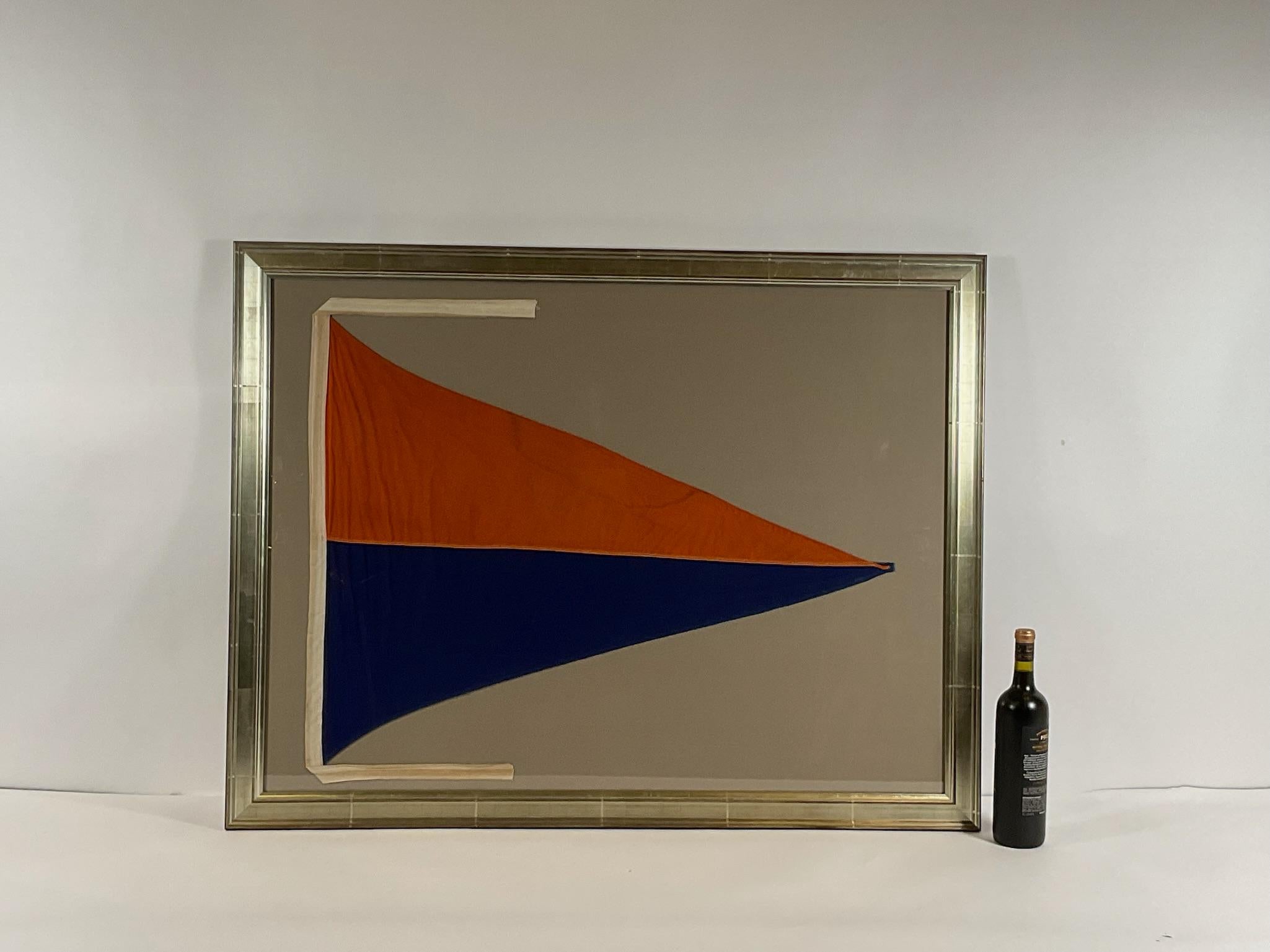 Maritime signal flag in frame showing a large flag stitched in panels of deep orange and blue. With stitched cloth hoist. Large and decorative for the money. Great piece of nautical décor. Circa 1955

Weight: 17 lbs.
Overall Dimensions: 34
