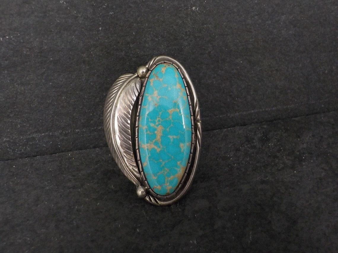 This gorgeous ring comprised of sterling silver and natural turquoise.
It is the creation of the late Navajo silversmith Fred Guerro.

Size 6
The face measurements 1 inch east to west and 1 9/16 inches north to south.
Weight: 16.2