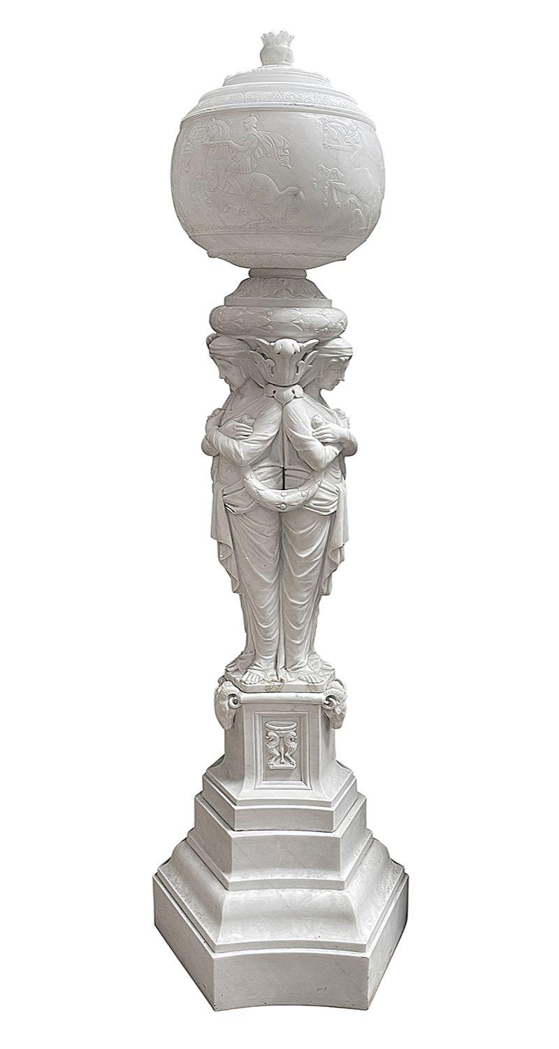 A fine quality late 19th Century Carrera Marble Neo-Classical Egyptian revival lamp, engraved with wonderful hand carved scenes of gladiators on horseback and chariots, raised above three Caryatids standing back to back and raised on a triform