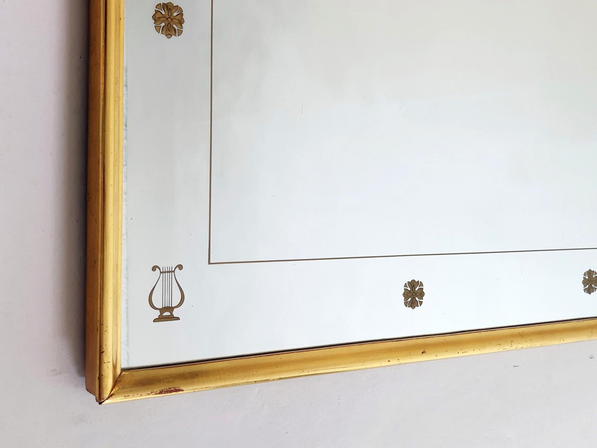 An extaordinary large full lenght wall mirror from the 1950's with a neoclassic design in the manner of Gio Ponti. The glass is in very good condition with small decorations in gold in the shape of lyras and roses. The frame and construction is made