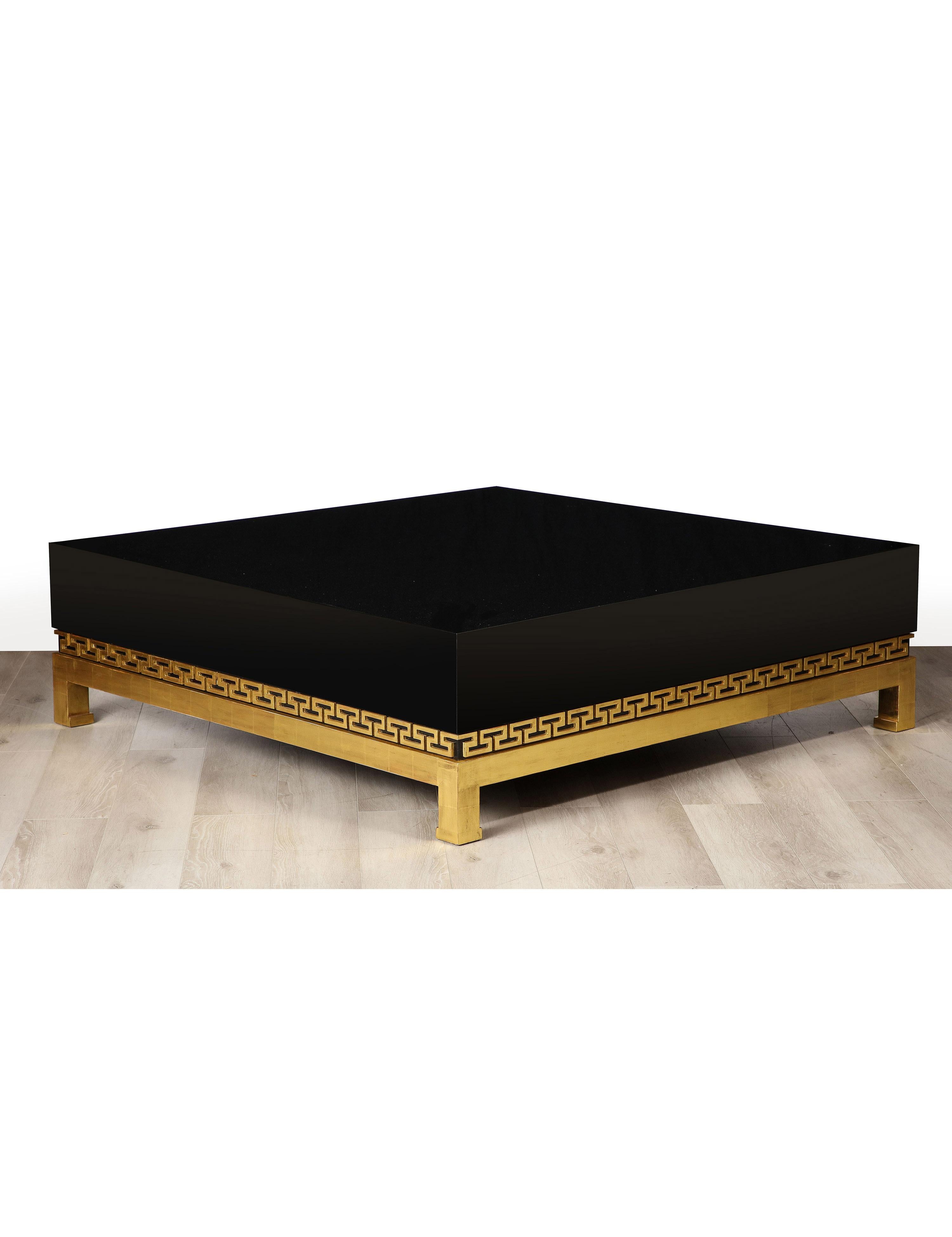 Table basse néoclassique de grande taille en bois laqué et doré avec un plateau en laque noire polie et des détails de clés grecques en bois doré sur une base en bois doré.
