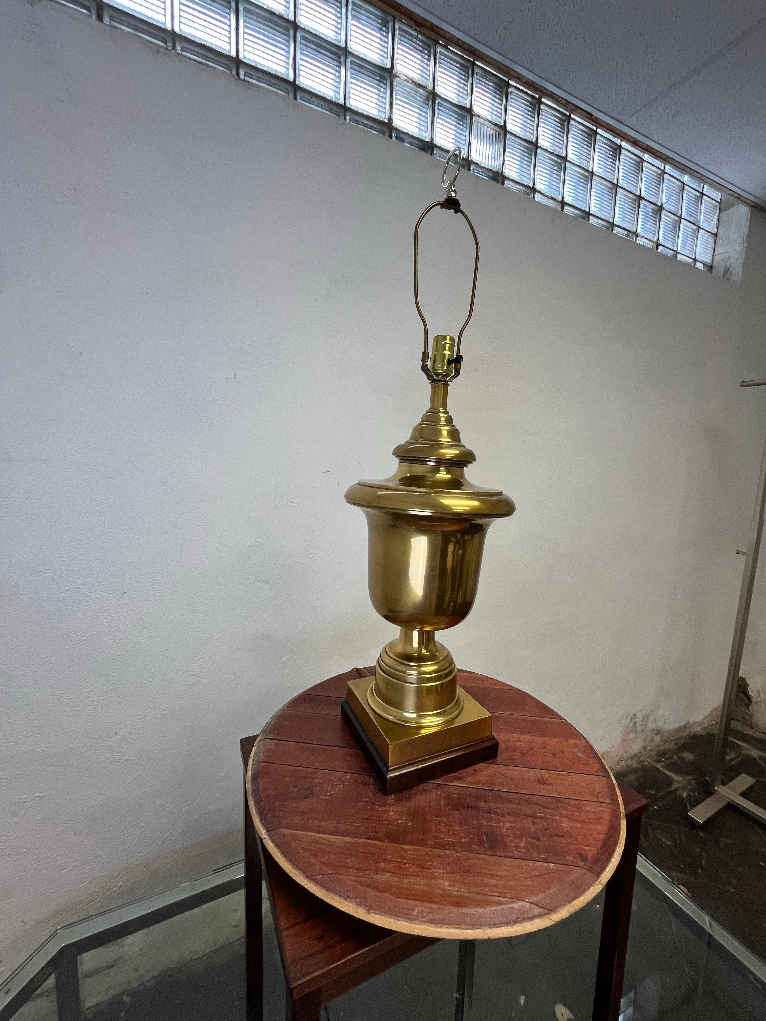 Stately urn shaped solid brass table lamps features large neoclassical style urn on square ebonized bases. As shown without shades they stand 26 inches tall making an impressive statement.