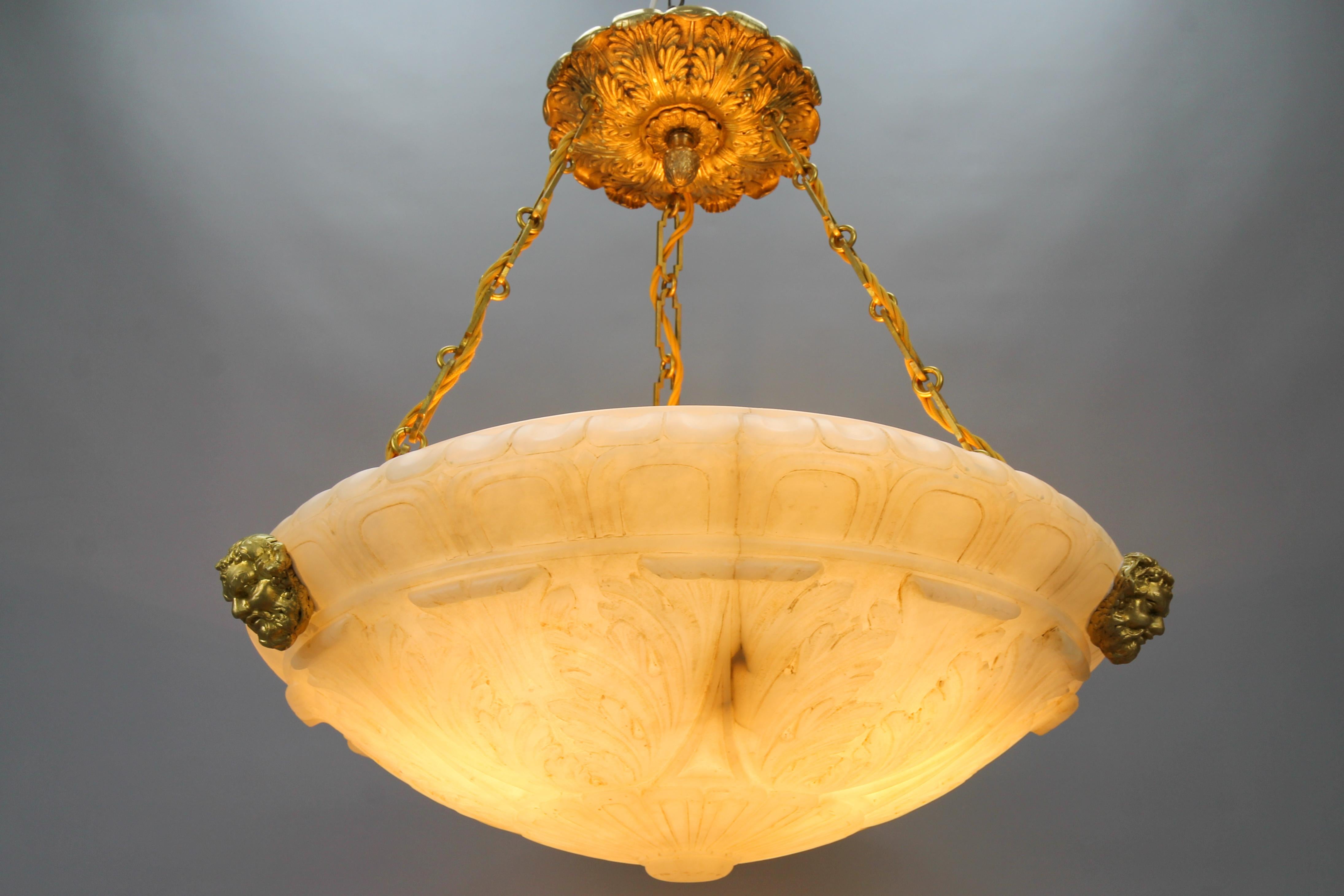 Large French Neoclassical style alabaster and bronze pendant light fixture, ca. 1890.
An impressive late 19th-century alabaster ceiling pendant light. The extra large, beautiful, and masterfully carved soft white/ivory tone alabaster bowl features